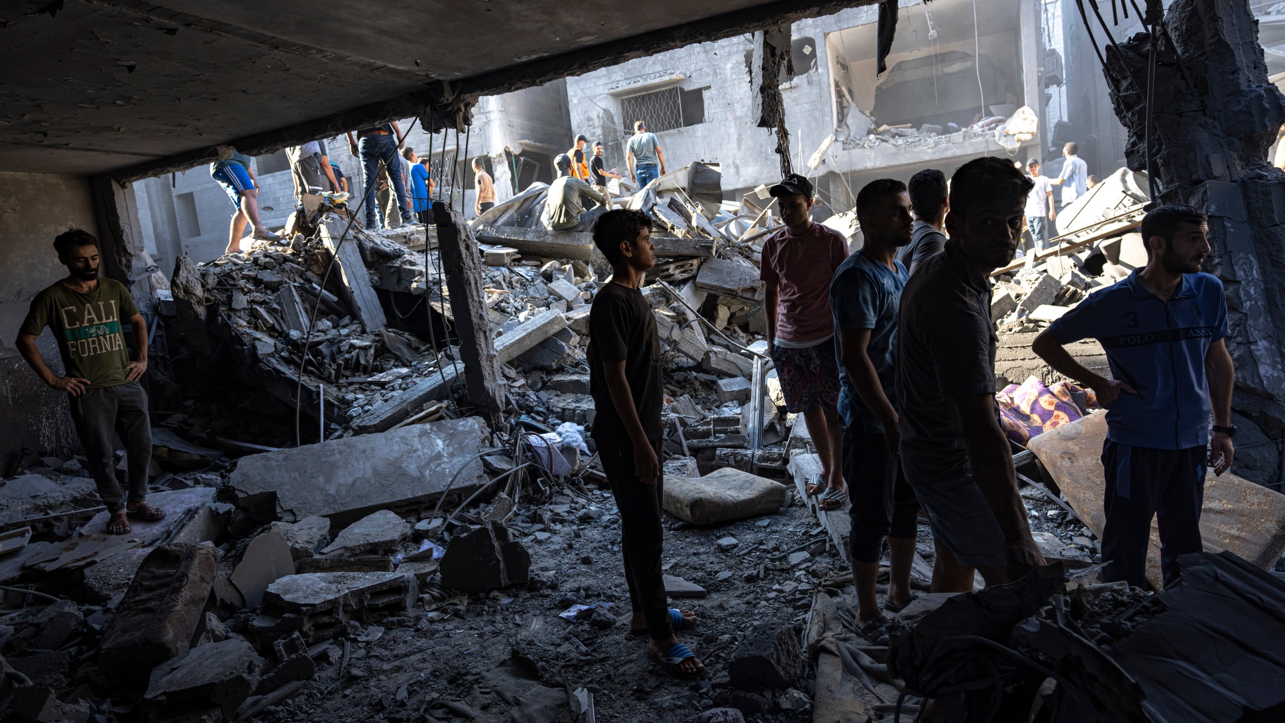 Palestinians search for bodies and survivors in the rubble of a residential building leveled in an Israeli airstrike, Al Shati Refugee Camp Thursday, Oct. 12, 2023. Israel's retaliation has escalated after Gaza's militant Hamas rulers launched an unprecedented attack on Israel Saturday, killing over 1,200 Israelis and taking captive dozens. Heavy Israeli airstrikes on the enclave has killed over 1,200 Palestinians. (AP Photo/Fatima Shbair)