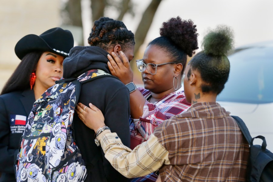 FILE - Darryl George, center left, a 17-year-old junior, and his mother Darresha George, center right, share words of encouragement before walking across the street to go into Barbers Hill High School after Darryl served a 5-day in-school suspension for not cutting his hair Monday, Sept. 18, 2023, in Mont Belvieu. George began attending a disciplinary program this week away from his classmates and regular teachers. He said in an interview with The Associated Press that he has felt isolated from and discouraged about not being able to play football or be more involved in campus events.(AP Photo/Michael Wyke, File)