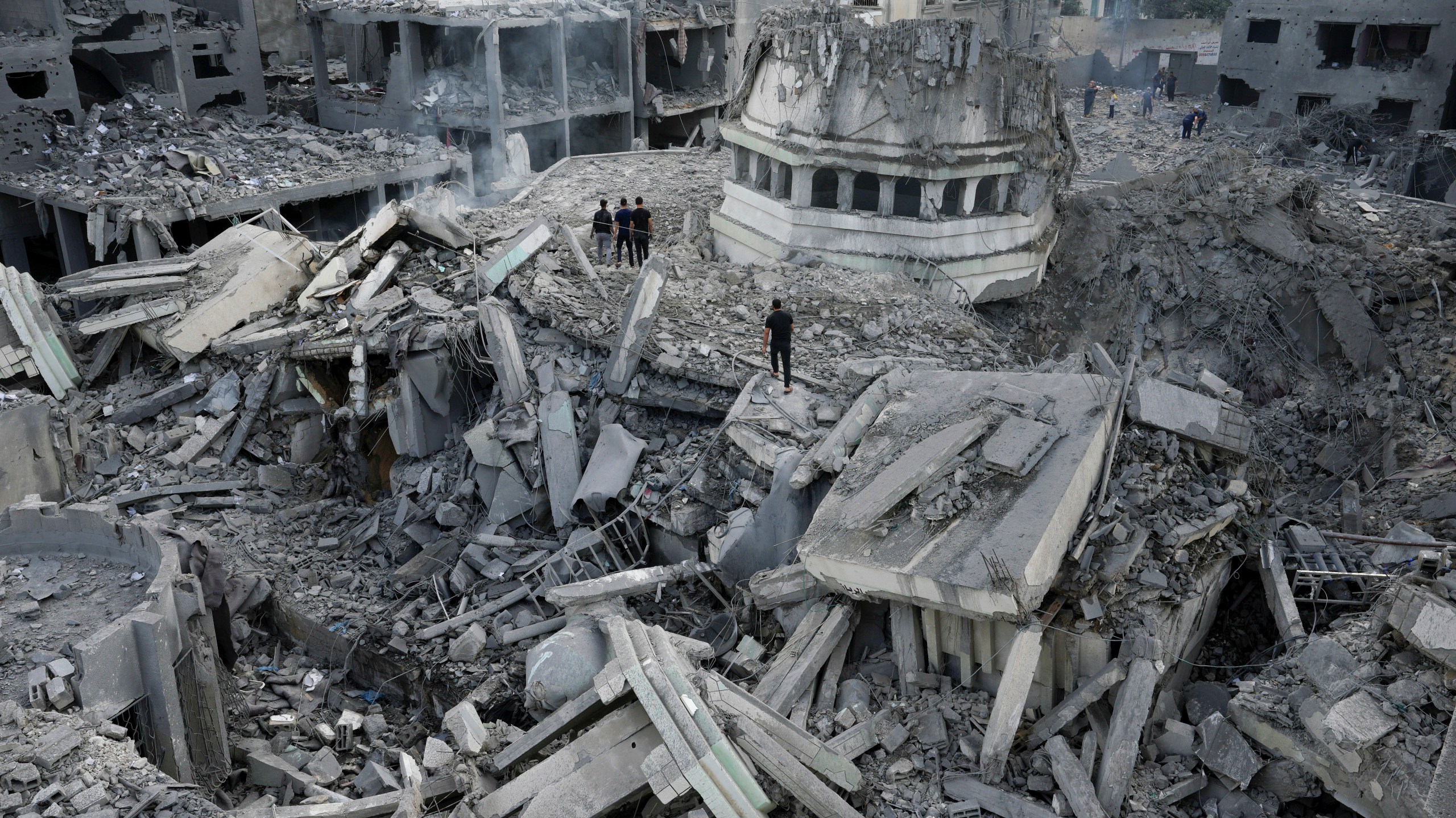 Palestinians inspect the rubble of the Yassin Mosque destroyed after it was hit by an Israeli airstrike at Shati refugee camp in Gaza City, early Monday, Oct. 9, 2023. Israel's military battled to drive Hamas fighters out of southern towns and seal its borders Monday as it pounded the Gaza Strip. (AP Photo/Adel Hana)