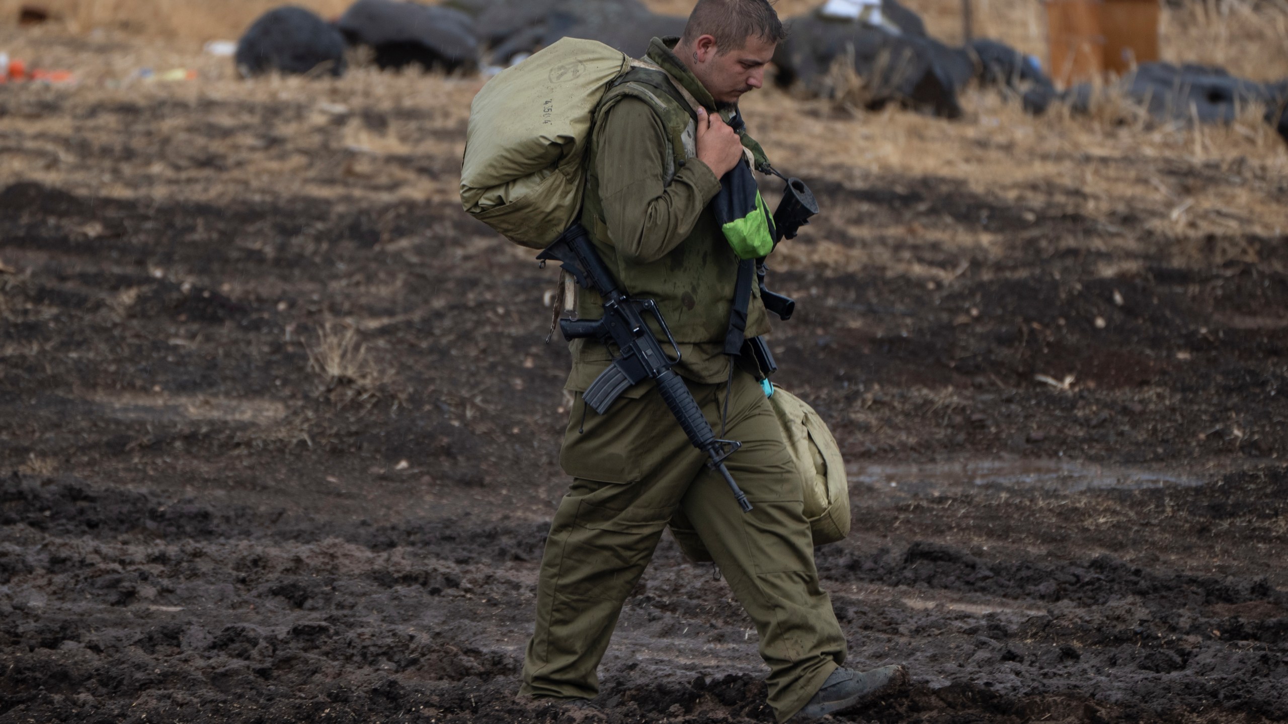 An Israeli soldier, walks during a rainfall near the Israeli border with Lebanon, on Sunday, Oct. 15, 2023.(AP Photo/Petros Giannakouris)