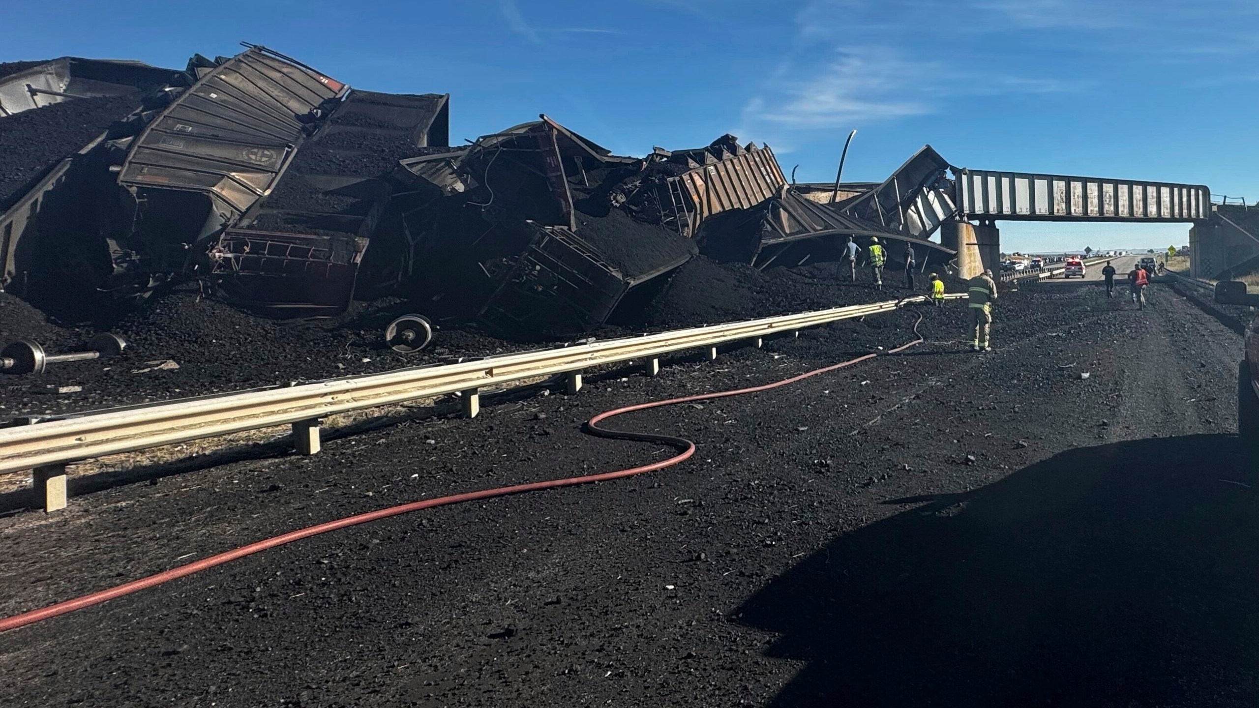 In this photo released by the Pueblo County Sheriff's Office, police respond to the scene of a train derailment near Pueblo, Colo., Sunday, Oct. 15, 2023. The train derailment Sunday spewed coal and mangled train cars across the highway. (Joshua Johnson/Pueblo County Sheriff's Office via AP)