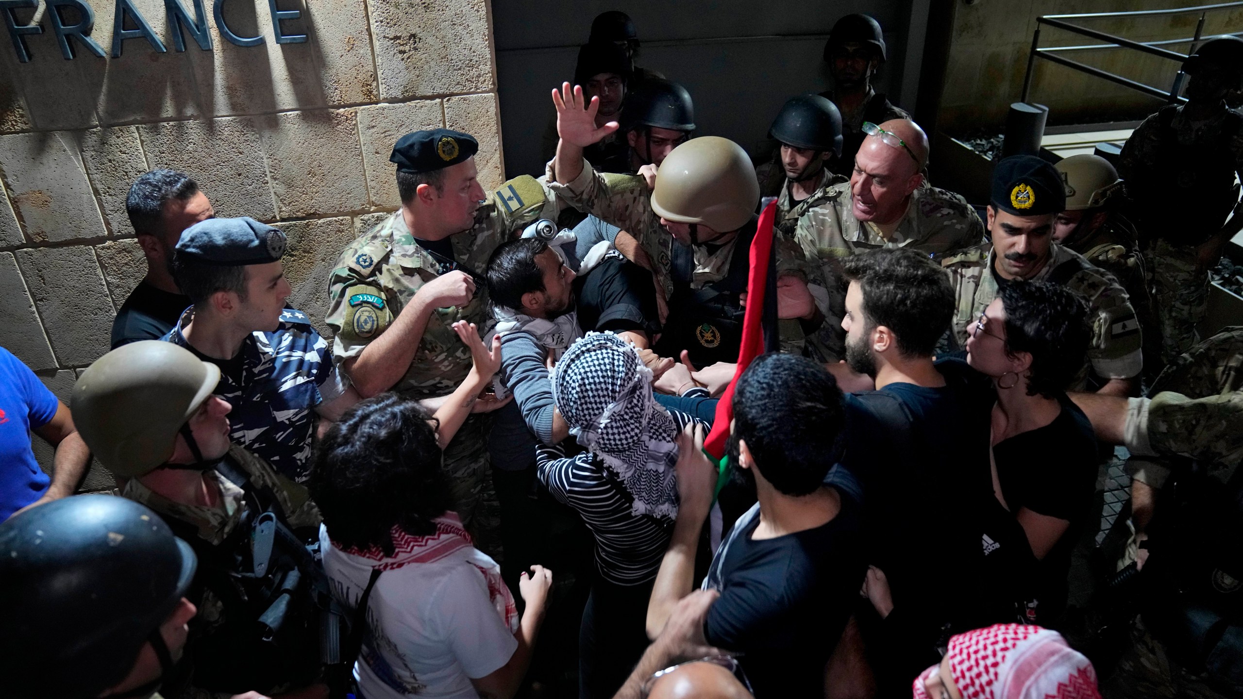 Demonstrators clash with the Lebanese army and riot police as they try to enter the French embassy during a protest in solidarity with the Palestinian people in Gaza, in Beirut, Lebanon, Tuesday, Oct. 17, 2023. Groups of protesters roamed the city on motorcycles and gathered outside the French embassy, and the headquarters of the U.N. Economic and Social Commission for Western Asia. They were unable to reach the heavily fortified U.S. embassy compound in the hills north of Beirut. (AP Photo/Bilal Hussein)