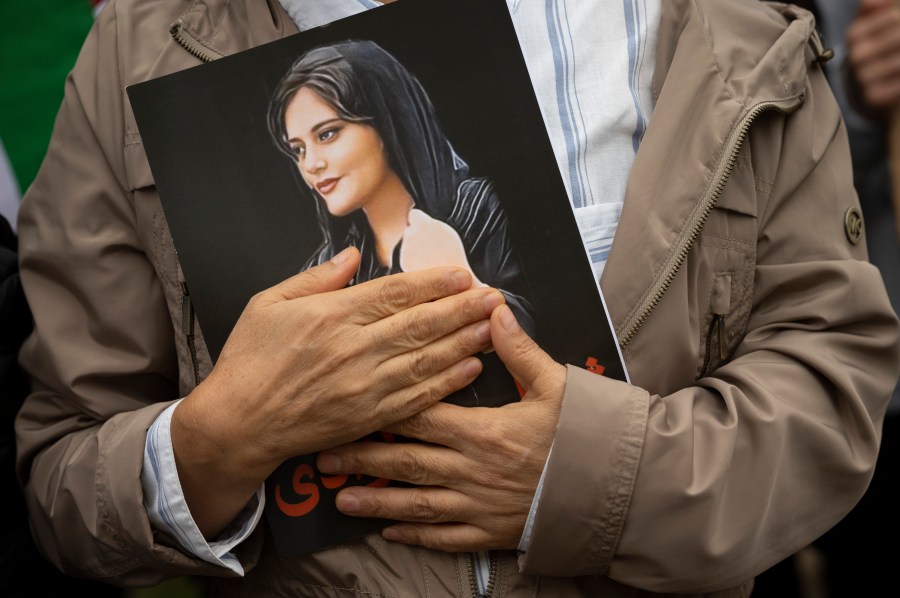 FILE - A portrait of Mahsa Amini is held during a rally calling for regime change in Iran following the death of Amini, a young woman who died after being arrested in Tehran by Iran's notorious "morality police," in Washington, on Oct. 1, 2022. Mahsa Amini, the 22-year-old Kurdish-Iranian woman who died in police custody in Iran last year, sparking worldwide protests against the country’s conservative Islamic theocracy, was awarded the European Union’s top human rights prize on Thursday, Oct. 19, 2023. (AP Photo/Cliff Owen, File)