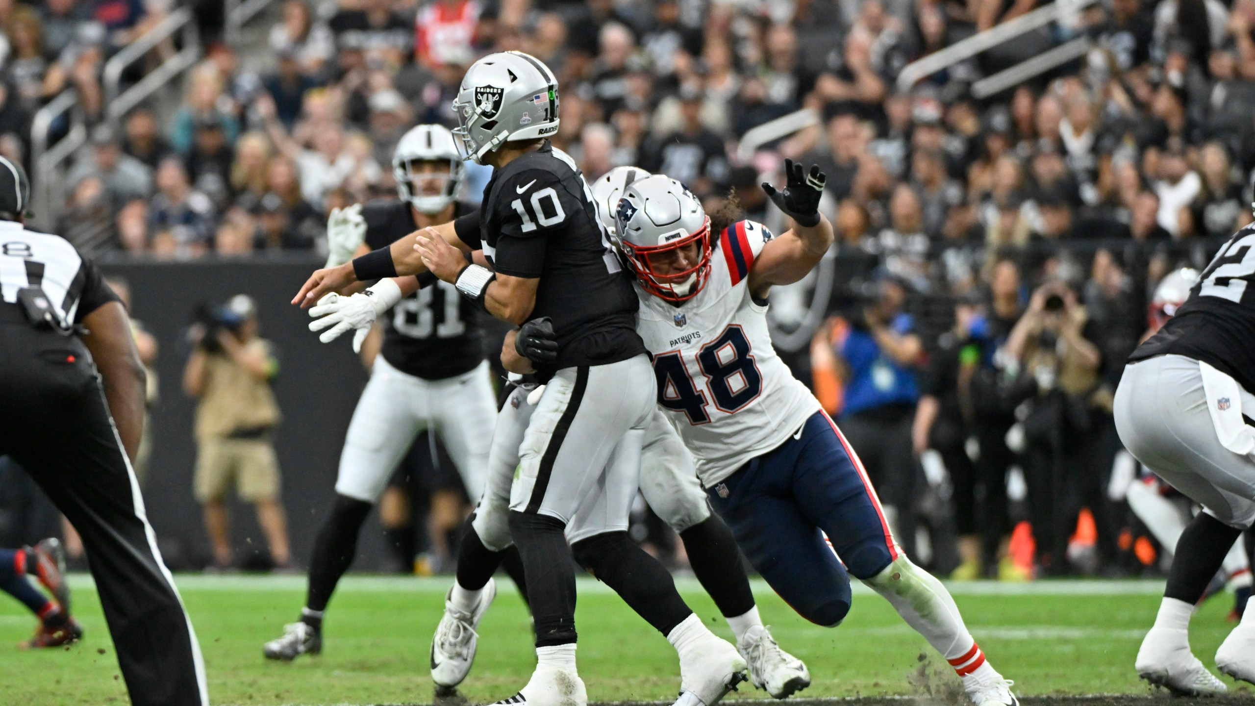 Las Vegas Raiders quarterback Jimmy Garoppolo is hit by New England Patriots linebacker Jahlani Tavai during the first half of an NFL football game Sunday, Oct. 15, 2023, in Las Vegas. (AP Photo/David Becker)