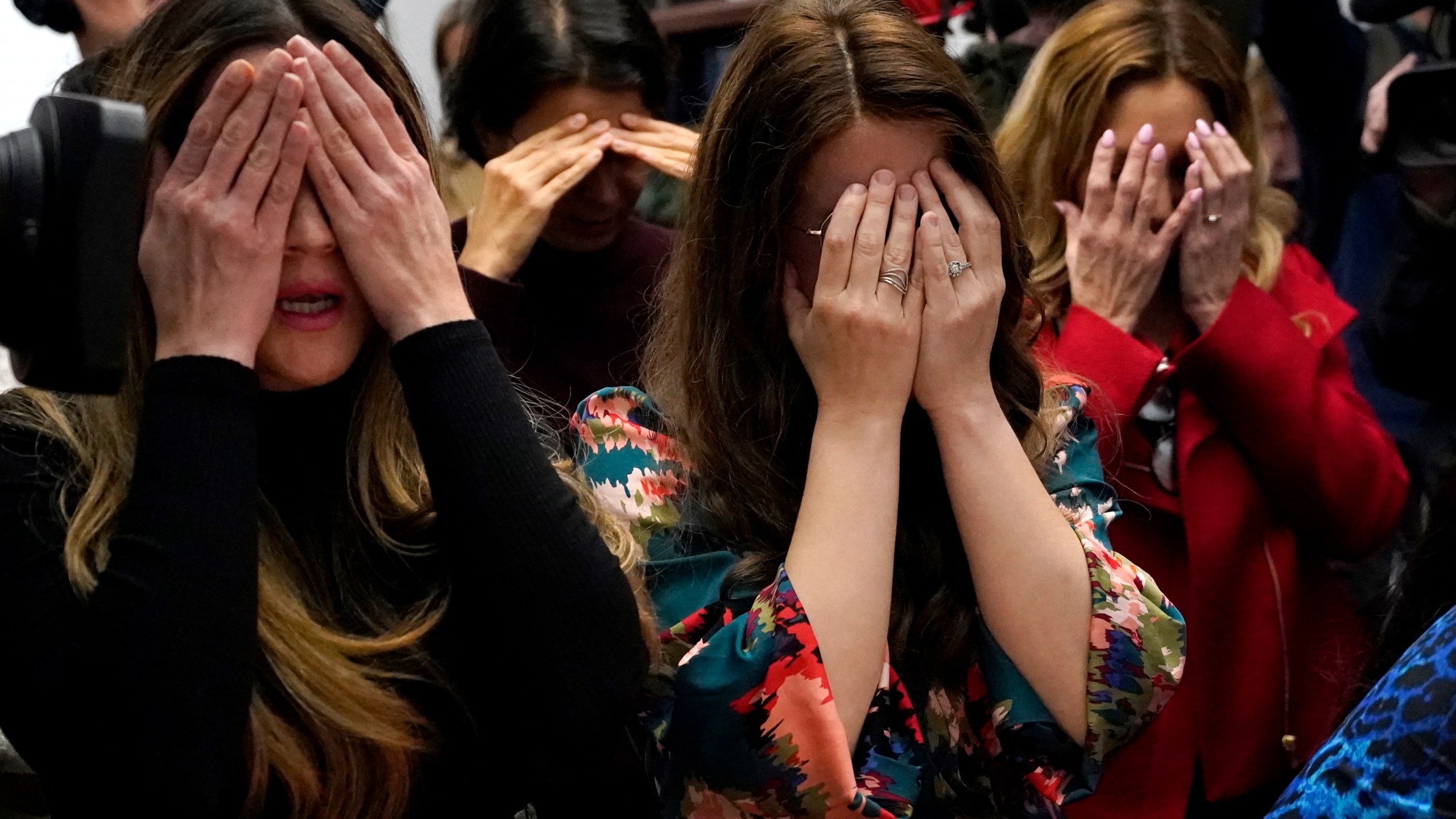 Members of the Chabad of Evanston, Ill., where Judith Raanan attended, cover their eyes as they pray at the beginning of Shabbat on Friday, Oct. 20, 2023, in Evanston. Raanan and her daughter Natalie were released Friday from their captivity in Gaza. (AP Photo/Charles Rex Arbogast)