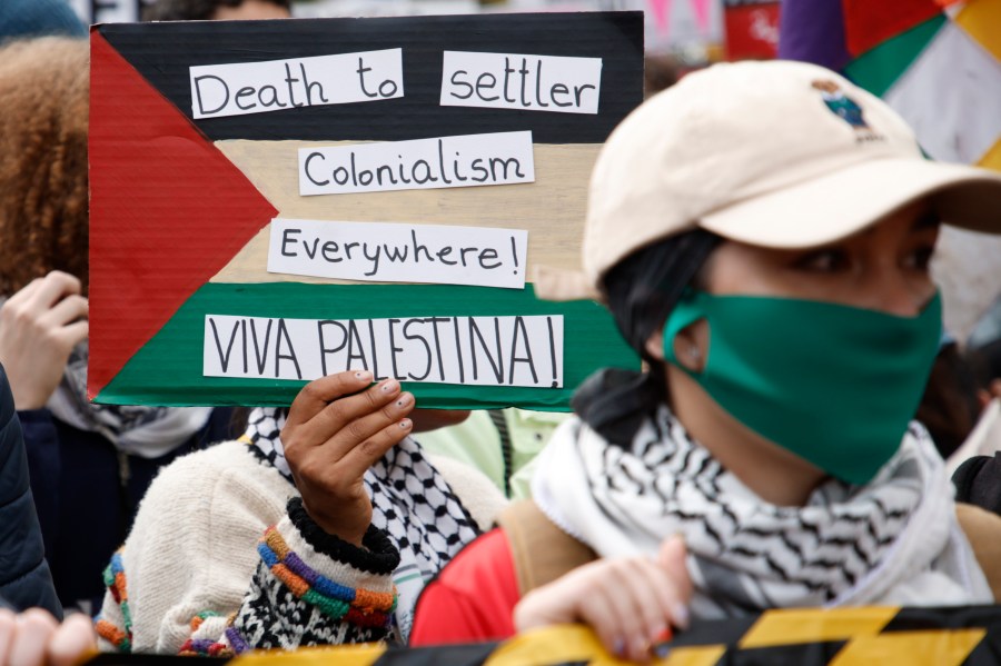 Demonstrators hold up flags and placards during a pro Palestinian demonstration in London, Saturday, Oct. 21, 2023. (AP Photo/David Cliff)