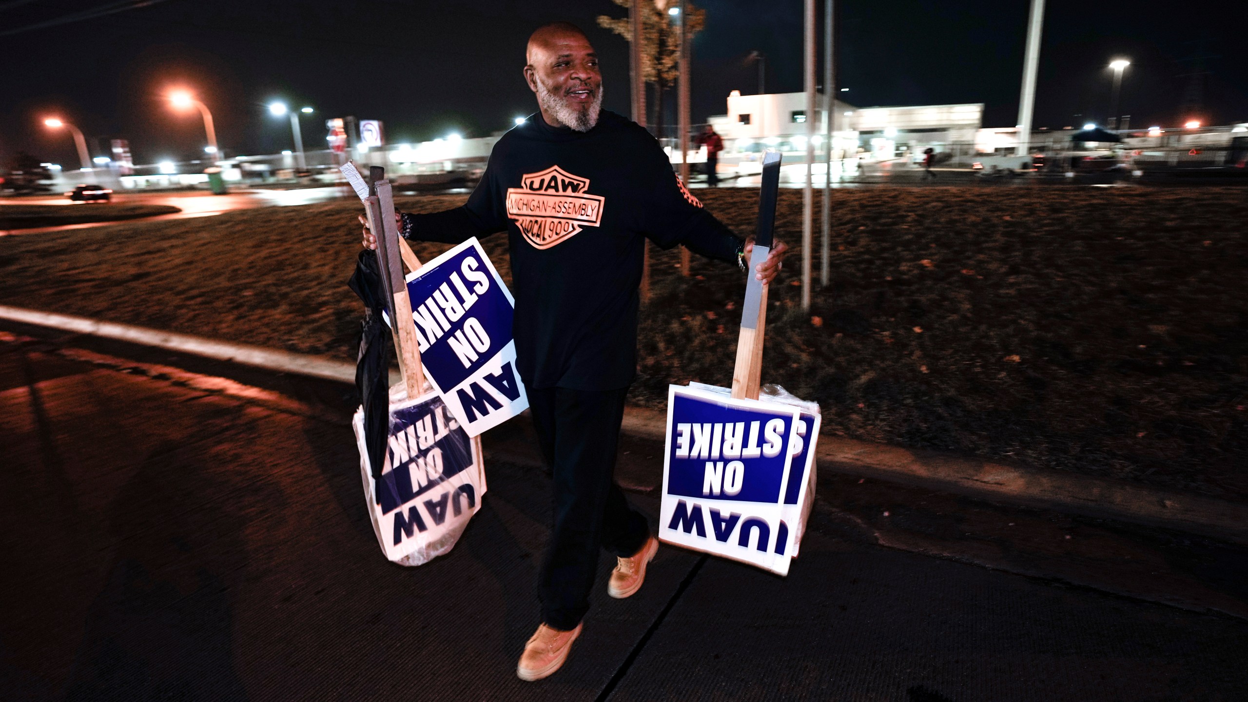 United Auto Workers member Marcel Edwards carries On Strike signs from the picket line to Local 900 headquarters at the Ford Michigan Assembly Plant in Wayne, Mich., Wednesday, Oct. 25, 2023. The United Auto Workers union said Wednesday it has reached a tentative contract agreement with Ford that could be a breakthrough toward ending the nearly 6-week-old strikes against Detroit automakers. (AP Photo/Paul Sancya)