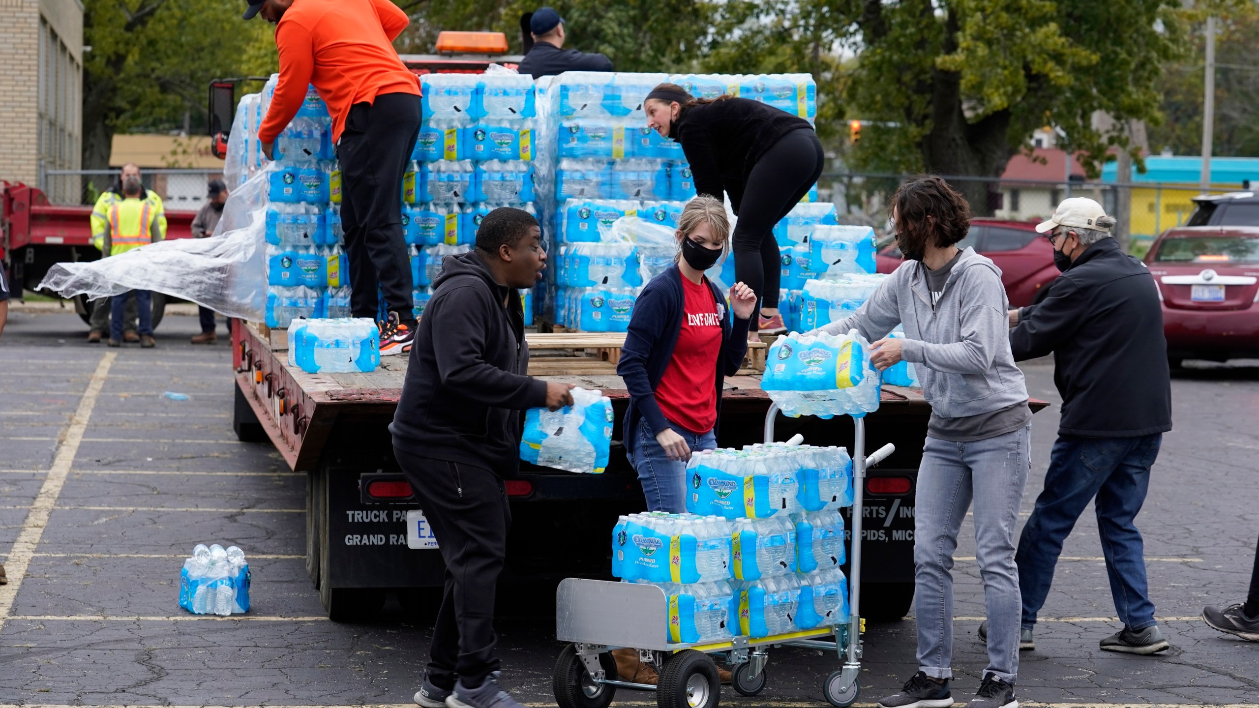 FILE - Volunteers prepare bottled water to be distributed to residents at the local high school parking lot Oct. 21, 2021, in Benton Harbor, Mich. The Environmental Protection Agency will soon strengthen lead in drinking water regulations. (AP Photo/Charles Rex Arbogast, File)