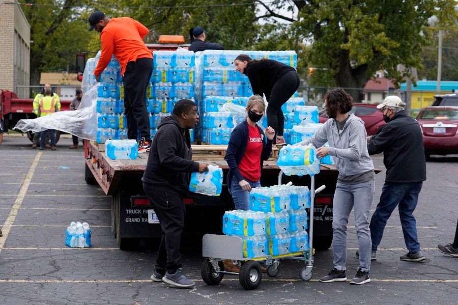 FILE - Volunteers prepare bottled water to be distributed to residents at the local high school parking lot Oct. 21, 2021, in Benton Harbor, Mich. The Environmental Protection Agency will soon strengthen lead in drinking water regulations. (AP Photo/Charles Rex Arbogast, File)