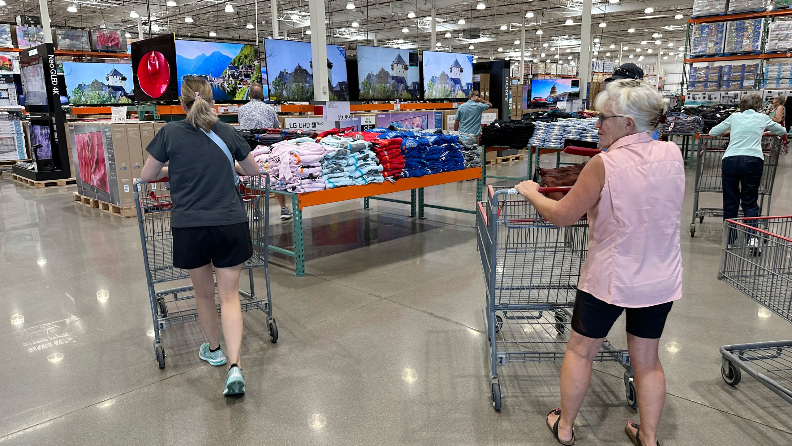 File - Shoppers push carts into a Costco warehouse Friday, Aug. 4, 2023, in Thornton, Colo. A surge in U.S. consumer spending is fueling economic growth, reflecting a resilience among households that has confounded economists, Federal Reserve officials and even the sentiments that Americans themselves have expressed in surveys.(AP Photo/David Zalubowski, File)