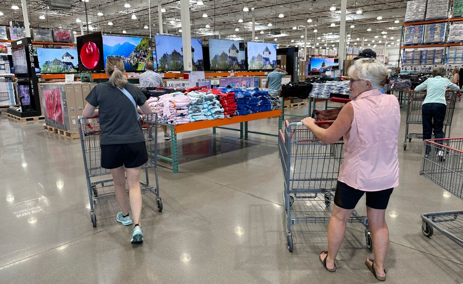 File - Shoppers push carts into a Costco warehouse Friday, Aug. 4, 2023, in Thornton, Colo. A surge in U.S. consumer spending is fueling economic growth, reflecting a resilience among households that has confounded economists, Federal Reserve officials and even the sentiments that Americans themselves have expressed in surveys.(AP Photo/David Zalubowski, File)