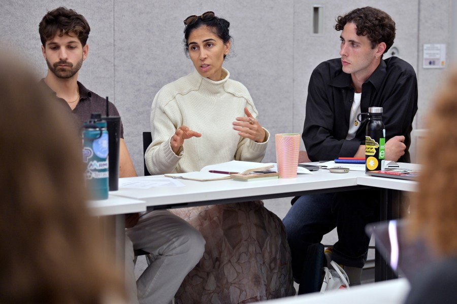 Leyla Uysal, a design school student from Harvard University with an urban planning background, center, speaks during a course concerning the conflicts that arise in the siting process of renewable energy projects, at the Massachusetts Institute of Technology, Friday, Sept. 15, 2023, in Cambridge, Mass. Mike Giovanniello, left, and Kailin Graham listen to the discussion. "It's going to be difficult, but I will educate myself not to take sides," Uysal said. (AP Photo/Josh Reynolds)