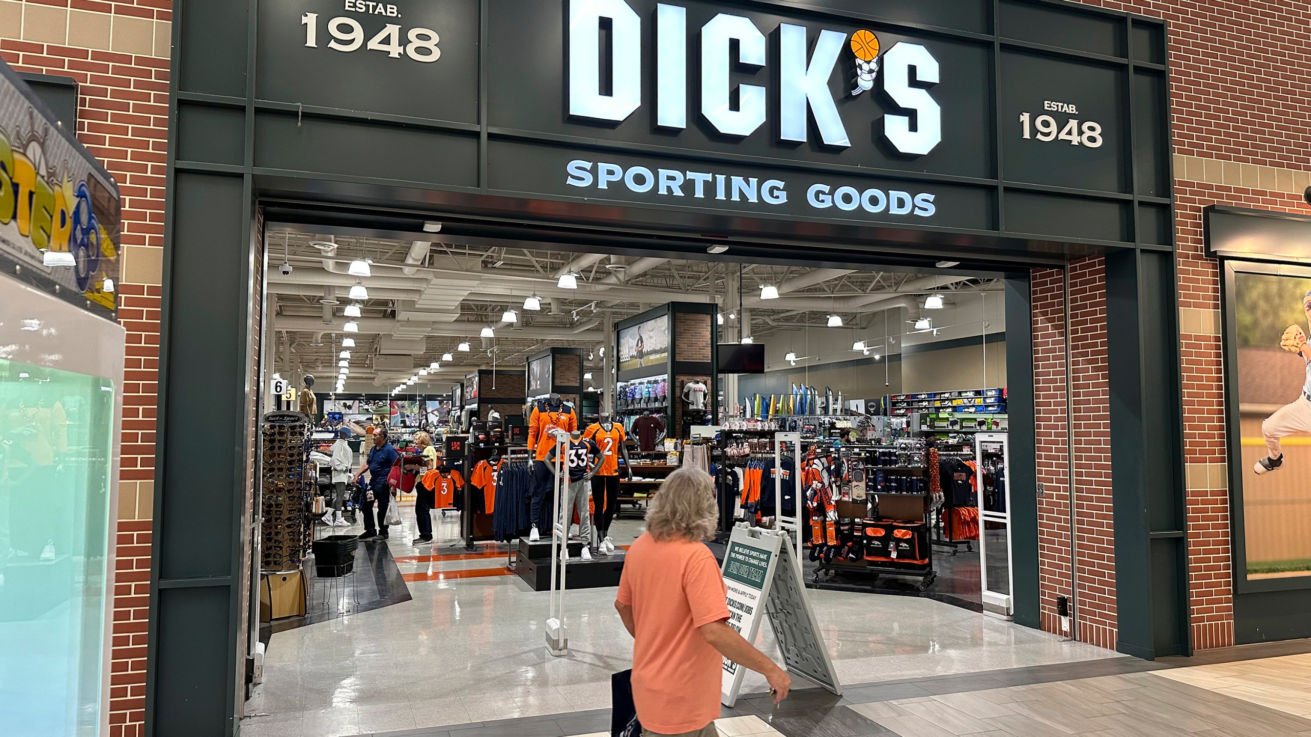 File - A shopper passes a Dick's Sporting Goods store on Aug. 24, 2023, in a shopping center in Lakewood, Colo. On Tuesday, the Conference Board reports on U.S. consumer confidence for October. (AP Photo/David Zalubowski, File)