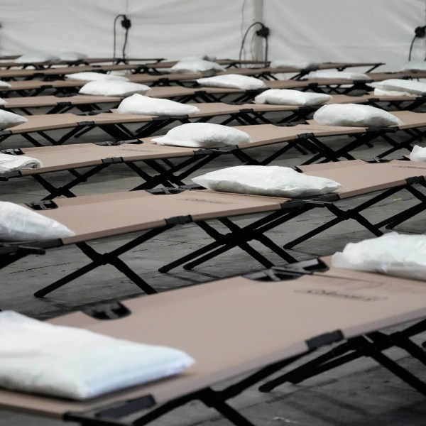 FILE - Bags containing a pillow, towel, and bed sheets are placed on cots inside the dormitory tent during a media tour of a shelter New York City is setting up to house up to 1,000 migrants in the Queens borough of New York, Aug. 15, 2023. Five mayors from around the U.S. want a meeting with President Joe Biden to ask for help controlling the continued arrival of large groups of migrants to their cities. The mayors of Denver, Chicago, Houston, New York and Los Angeles say in a letter to Biden that there has been little to no coordination, support or resources and that is leading to a crisis. (AP Photo/Mary Altaffer, File)