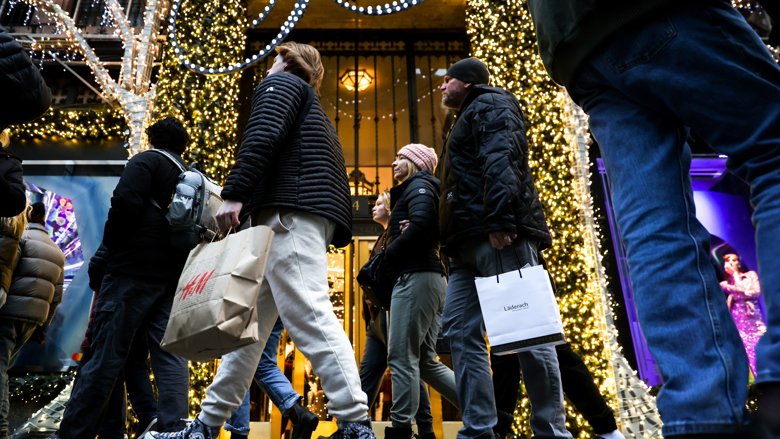 FILE - Shoppers carry shopping bags down Fifth Avenue, Monday, Dec. 19, 2022, in New York. The National Retail Federation, the nation’s largest retail trade group, expects holiday sales growth will ease to a range of 3% to 4%, compared with 5.4% growth a year ago. The forecast, released Thursday, Nov. 2, 2023, comes as shoppers keep spending, powered by sturdy hiring, low unemployment and healthy household finances. (AP Photo/Julia Nikhinson, File)