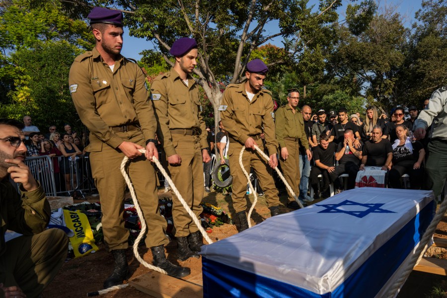 Israeli soldiers lower the coffin of late Israeli Staff Sergeant Shay Arvas at the Holon military cemetery, outskirts of Tel Aviv, Israel, Thursday, Nov. 2, 2023. Sergeant Arvas, 20, was killed on Oct 31, during IDF's ground operation in Gaza Strip. (AP Photo/Bernat Armangue)