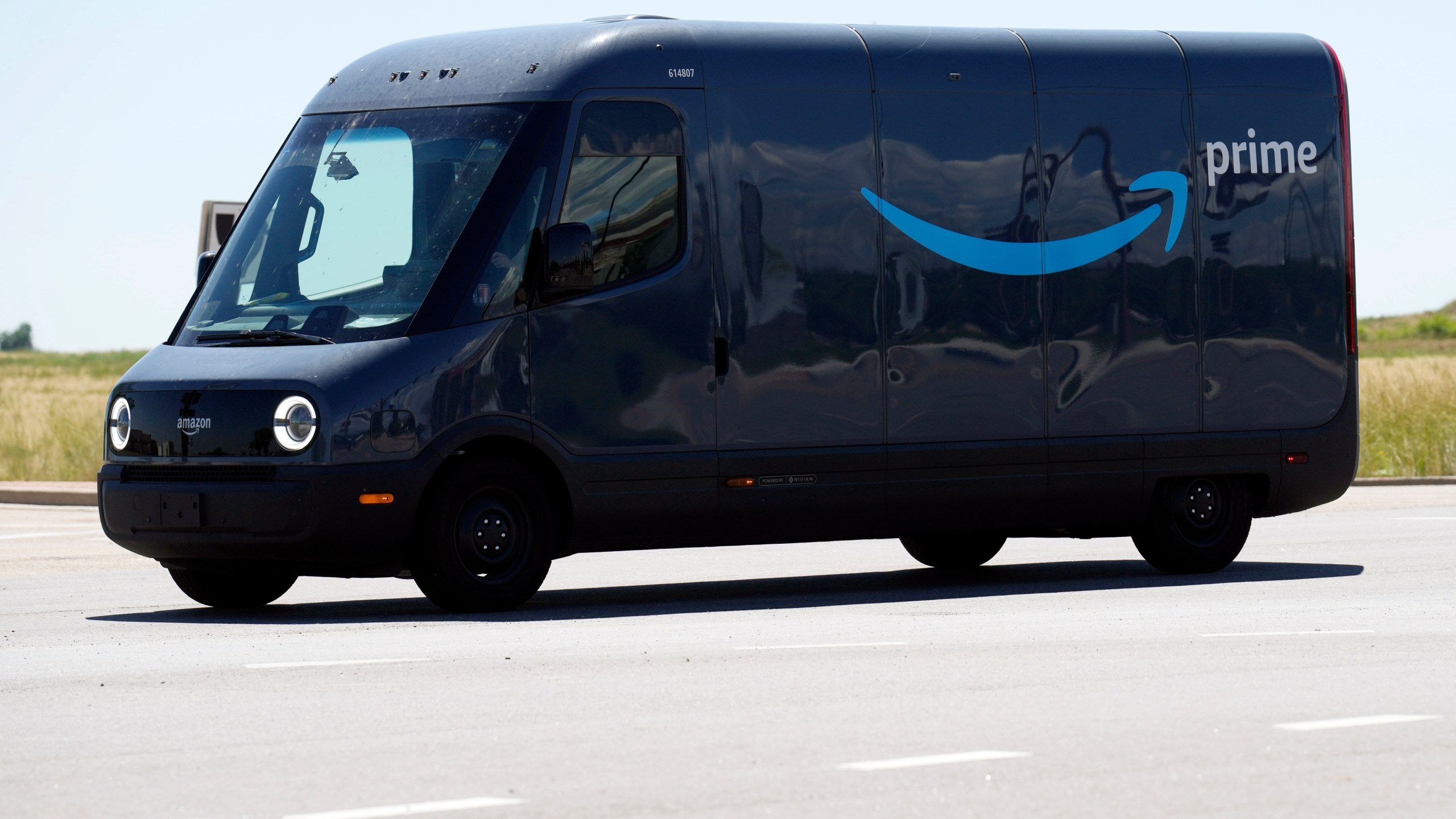 FILE- An driver drives a Rivian electric van as packages are delivered for Amazon Prime, Friday, Aug. 4, 2023, in Thornton, Colo. Electric vehicle maker Rivian said Tuesday, Nov. 7, 2023, that it will allow other companies to purchase its fleet of delivery vans and end its exclusive agreement with Amazon. (AP Photo/David Zalubowski, File)