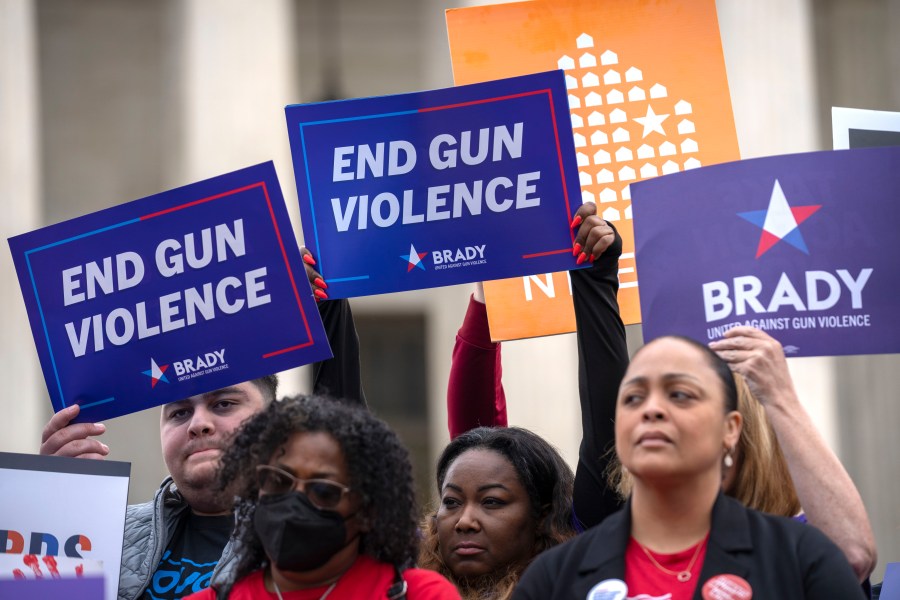 Demonstrators hold signs reading "End Gun Violence" at the Supreme Court on Tuesday, Nov. 7, 2023, in Washington. The Supreme Court is taking up a challenge to a federal law that prohibits people from having guns if they are under a court order to stay away from their spouse, partner or other family members. (AP Photo/Mark Schiefelbein)