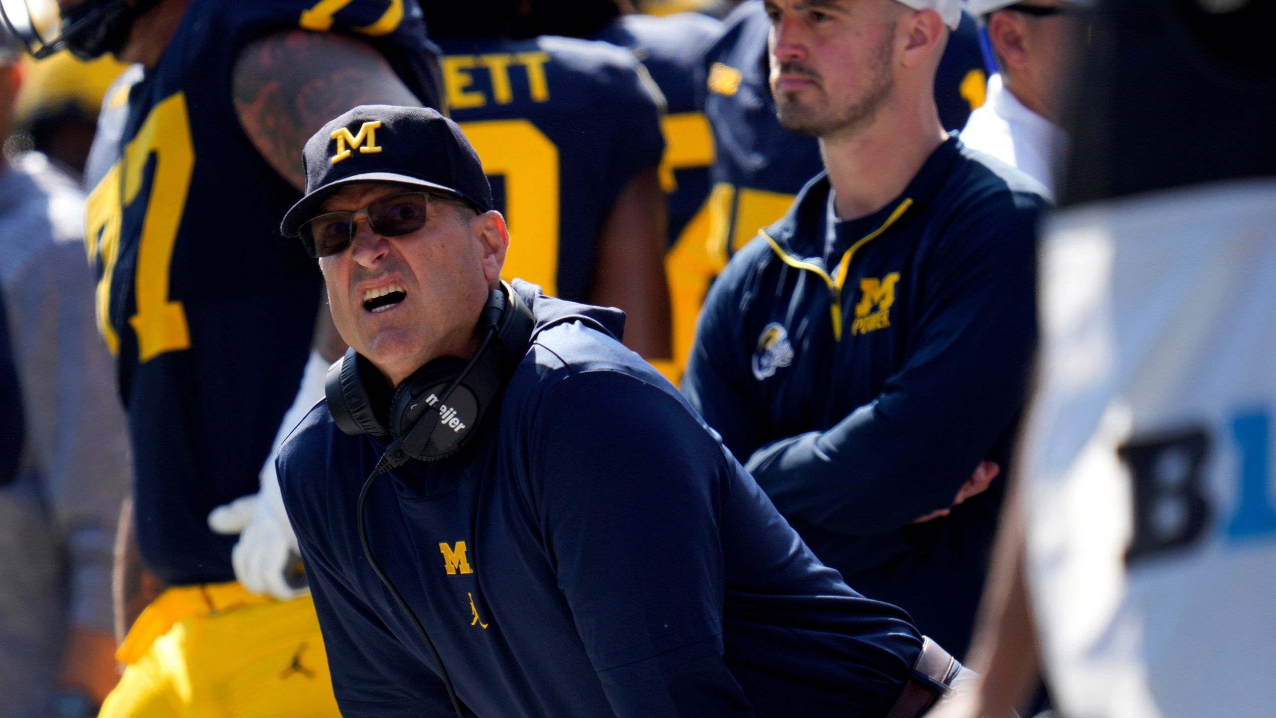 Michigan head coach Jim Harbaugh, front left, watches against Rutgers as analytics assistant Connor Stalions, right, looks on during an NCAA college football game in Ann Arbor, Mich., Sept. 23, 2023. Stalions was suspended by the university last week and is at the center of a sign-stealing scheme that is being investigated by the NCAA. (AP Photo/Paul Sancya)