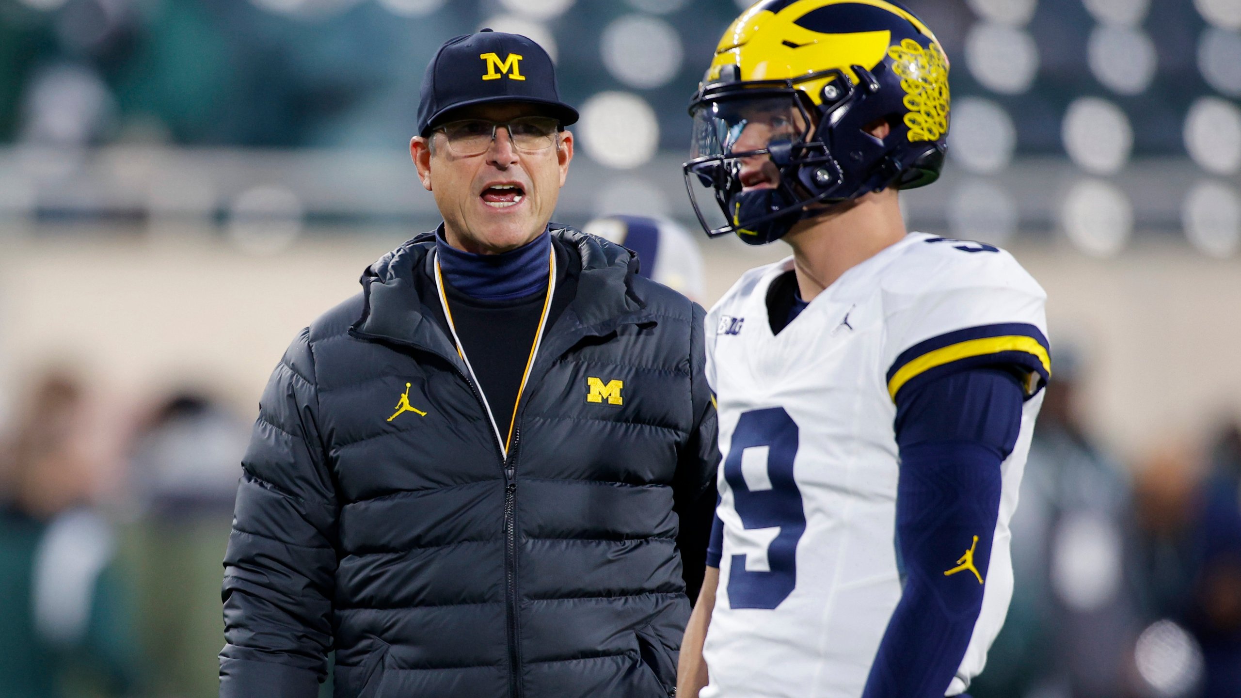 Michigan coach Jim Harbaugh, left, talks to quarterback J.J. McCarthy before an NCAA college football game against Michigan State, Saturday, Oct. 21, 2023, in East Lansing, Mich. (AP Photo/Al Goldis)