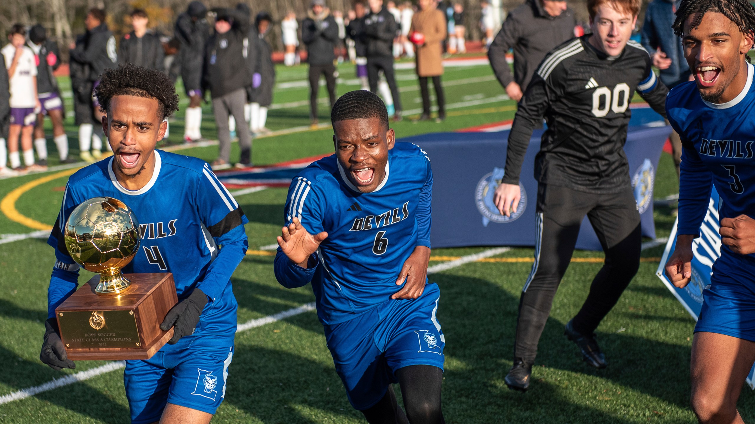 From left to right, Lewiston's Abdishakur Nur, Obed Antonio, Payson Goyette and Caden Boone celebrate Saturday, Nov. 12, 2023 in Oakland, Maine. The boy's team in the Maine city that was the site of a mass shooting more than two weeks ago won the state soccer title. (Russ Dillingham/Sun Journal via AP)