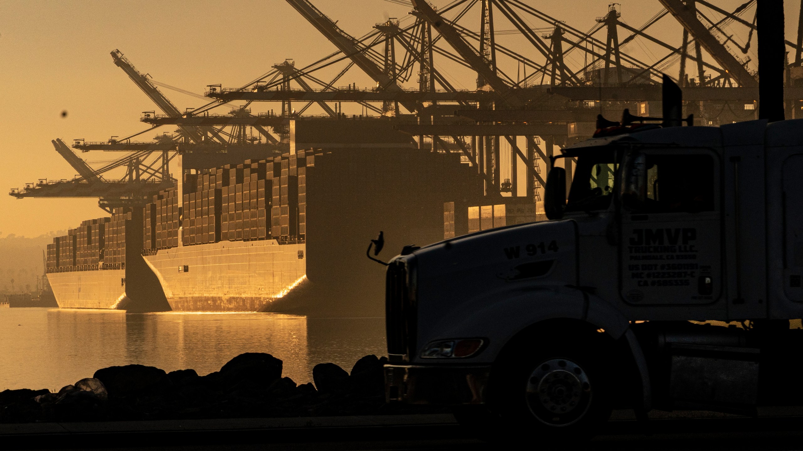 FILE - A truck arrives to pick up a shipping container near vessels moored at Maersk APM Terminals Pacific at the Port of Los Angeles, on Nov. 30, 2021. When President Joe Biden took office in 2021, he kept much of former President Trump’s combative trade policy in place, including the China tariffs. (AP Photo/Damian Dovarganes, File)