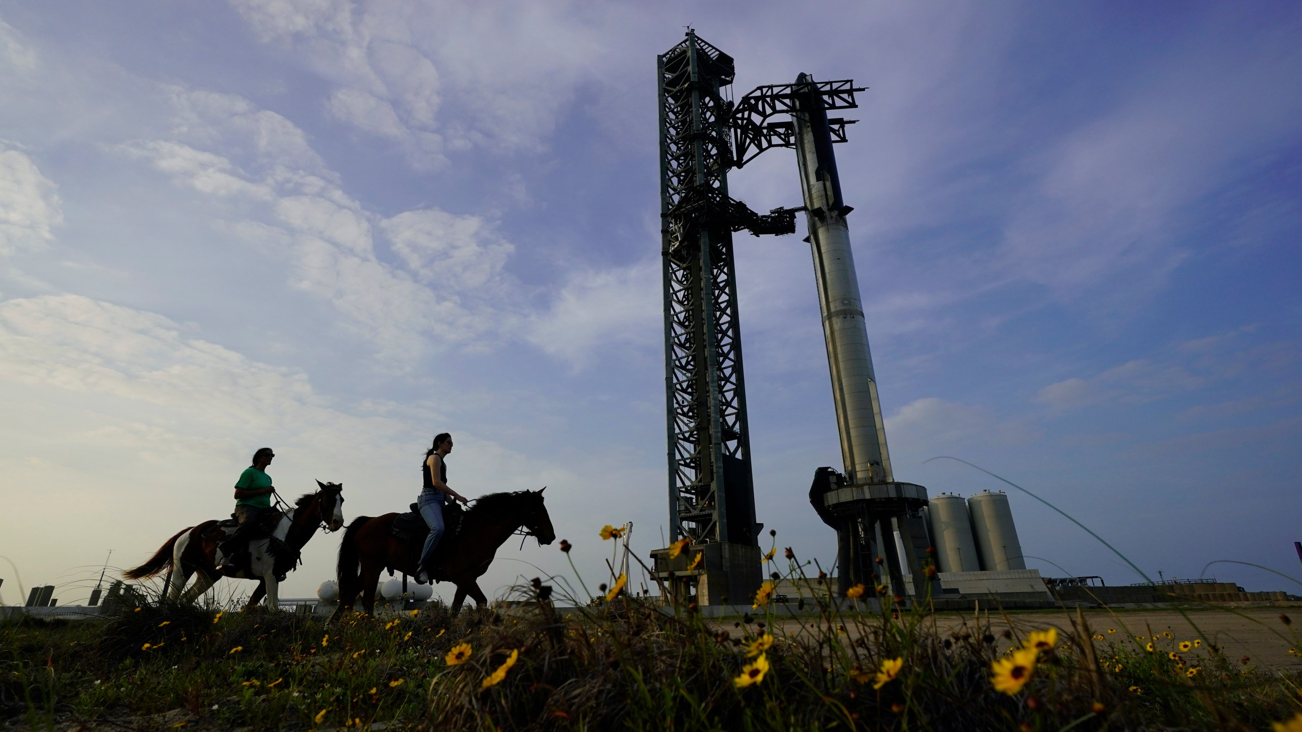 FILE - NASA astronaut Sunita Williams, left, and Haley Esparza ride on horses as they visit SpaceX's Starship, April 19, 2023, as it's readied for launch at Starbase in Boca Chica, Texas. SpaceX is aiming for another test flight of its mega rocket, Starship, on Friday, Nov. 17, after getting the final OK from the Federal Aviation Administration. The FAA issued its license Wednesday, Nov. 15, noting that SpaceX has met safety, environmental and other requirements. (AP Photo/Eric Gay, File)