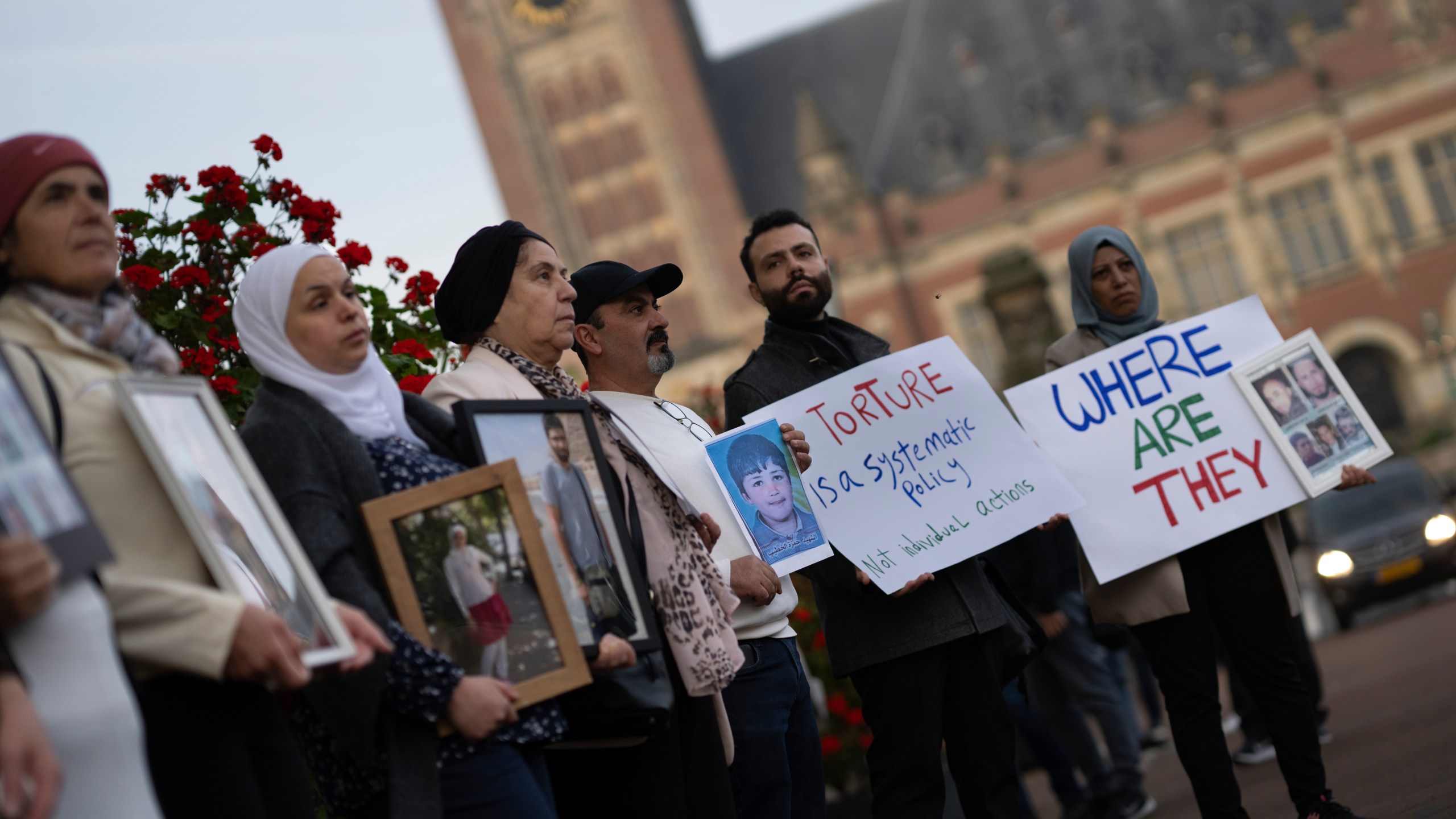 FILE - Demonstrators display pictures of people, they say disappeared in Syria, outside the International Court of Justice, or World Court, in The Hague, Netherlands, Tuesday, Oct. 10, 2023. The United Nations' top court on Thursday ordered the Syrian government to “take all measures within its powers” to prevent torture, in a case in which the Netherlands and Canada accuse Damascus of a years-long campaign of torturing its own citizens. (AP Photo/Peter Dejong, File)