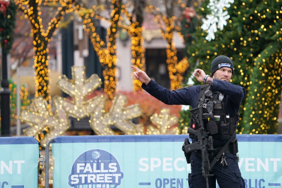 A Niagara Falls Police officer directs tourists in Niagara Falls, N.Y., away from the Rainbow Bridge border crossing after a car is reported to have exploded within the customs plaza, Wednesday, Nov. 22, 2023. (Derek Gee/The Buffalo News via AP)