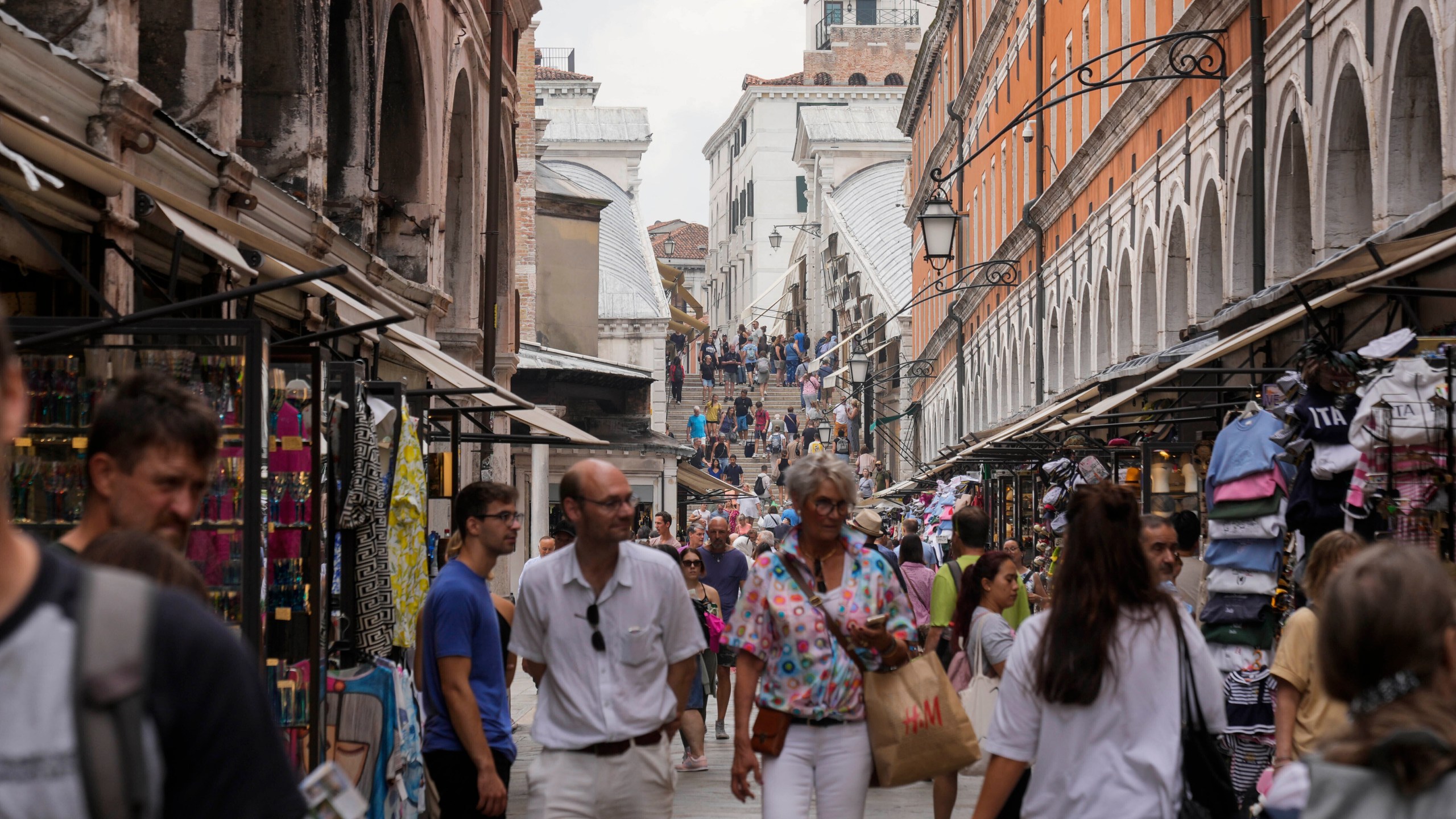 FILE -Tourists walk in a crowded street in Venice, Italy, Wednesday, Sept. 13, 2023. Venice authorities have rolled out a pilot program to charge day-trippers 5 euros ($5.45) apiece to enter the fragile lagoon city on peak weekends next year. The aim is to reduce crowds, encourage longer visits and improve the quality of life for residents. (AP Photo/Luca Bruno, File)