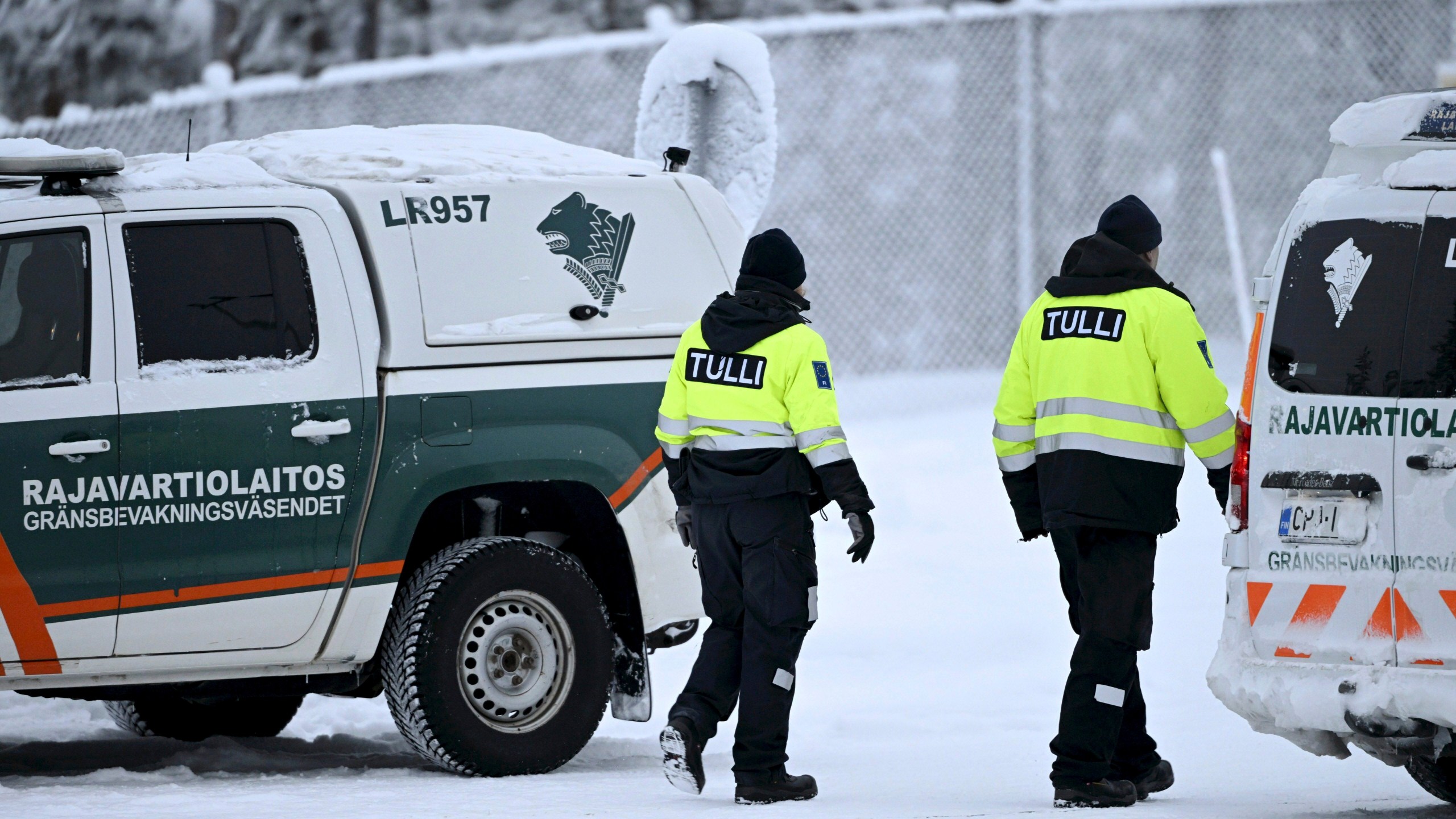 Customs officials walk between Finnish Border Guard vehicles at the Raja-Jooseppi international border crossing station with Russia, in Inari, northern Finland, on Tuesday, Nov. 28, 2023. Finland will close its last remaining road border with Russia due to concerns over migration, Prime Minister Petteri Orpo said Tuesday, accusing Moscow of undermining Finland's national security. Finland already closed seven of its eight of the checkpoints along its long border Russia this month following a surge in arrivals of migrants from the Middle East and Africa. The government accuses Moscow of ushering the migrants toward the Finnish border. (Emmi Korhonen/Lehtikuva via AP)