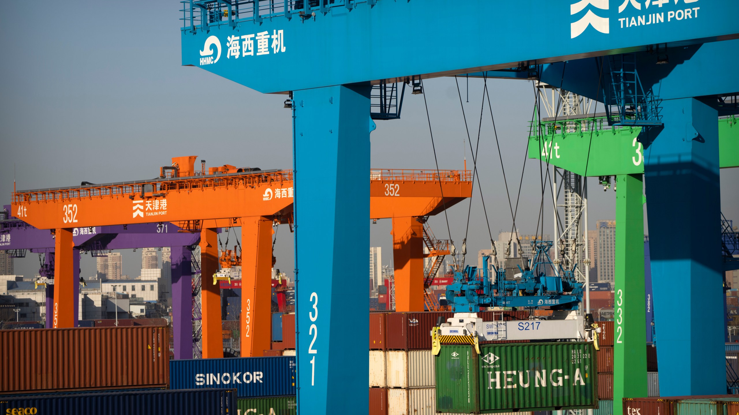 File - A crane lifts a shipping container at an automated container port in Tianjin, China, Jan. 16, 2023. The global economy, which has proved surprisingly resilient this year, is expected to falter next year under the strain of wars, still-elevated inflation and continued high interest rates. (AP Photo/Mark Schiefelbein, File)