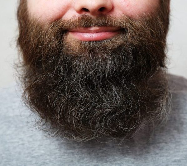 This image shows the lower half of a smiling, bearded man's face.
