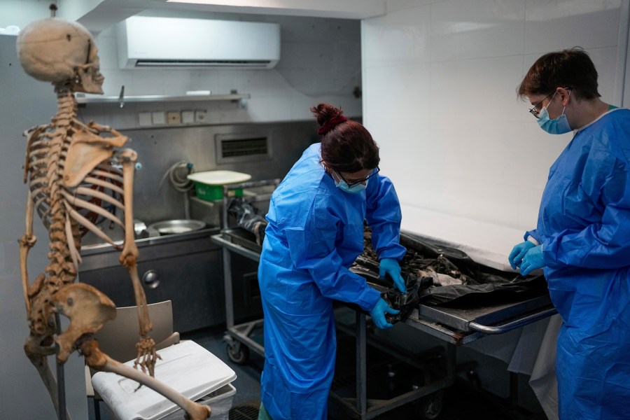 FILE - Israeli forensic experts work on bodies of Israelis killed by Hamas militants in the National Center for Forensic Medicine in Tel Aviv, Israel on Oct. 18, 2023. Nearly two months after Hamas infiltrated Israel, killing some 1,200 people and taking about 240 hostage, dozens are still unaccounted for, their families left living in limbo. (AP Photo/Ohad Zwigenberg, File)