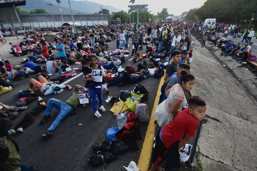 Migrants block the highway during their caravan through Huixtla, Mexico, Wednesday, Nov. 8, 2023. About 3,000 migrants, mostly from Central America, are protesting for the government to issue them temporary documents allowing them to continue north to the U.S. border. (AP Photo/Edgar Clemente)