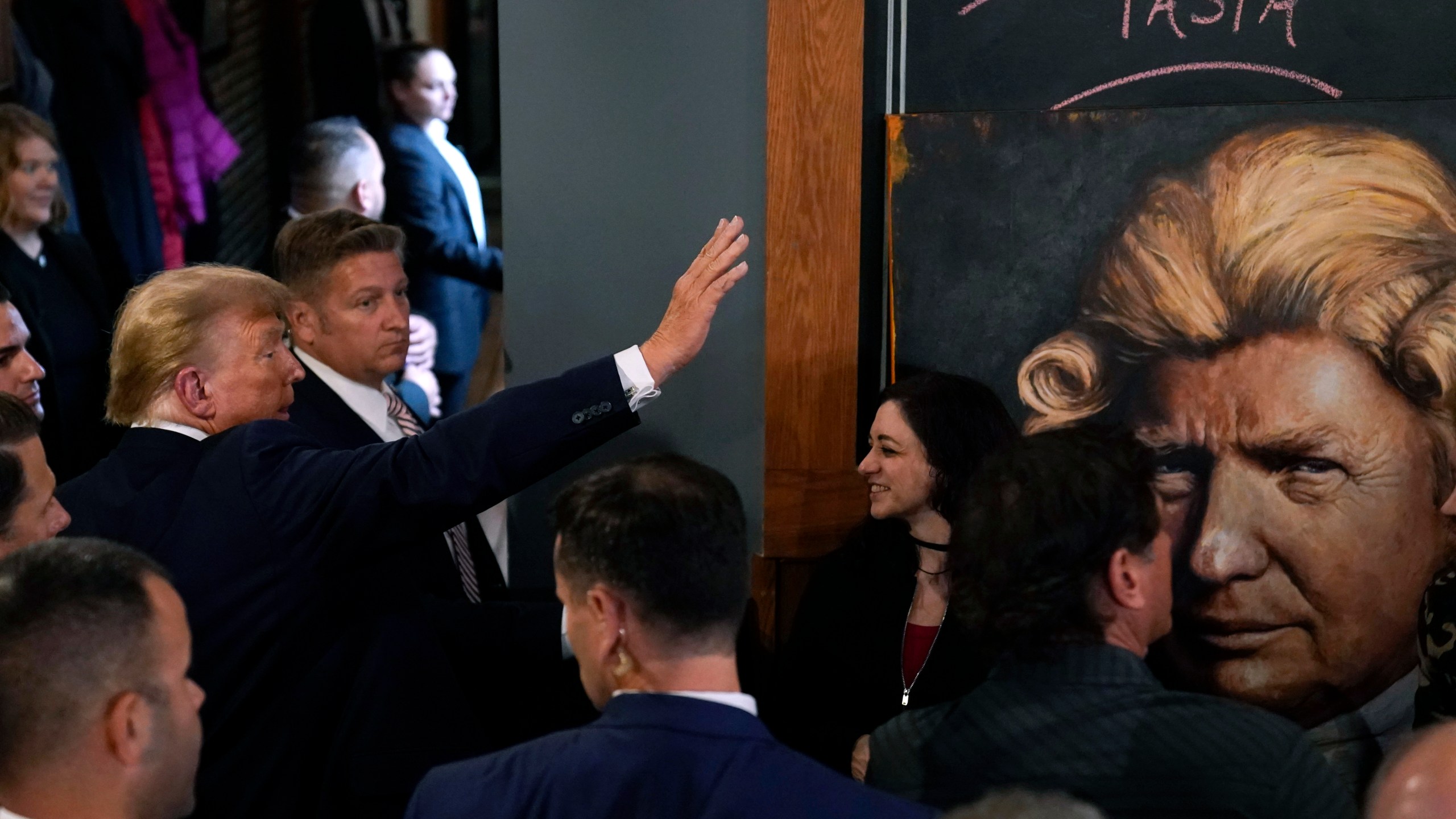 Former President Donald Trump greets supporters during a stop at the Front Street Pub & Eatery, Tuesday, Dec. 5, 2023, in Davenport, Iowa. (AP Photo/Charlie Neibergall)