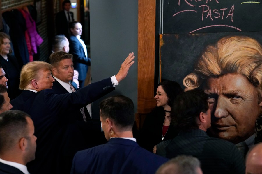 Former President Donald Trump greets supporters during a stop at the Front Street Pub & Eatery, Tuesday, Dec. 5, 2023, in Davenport, Iowa. (AP Photo/Charlie Neibergall)