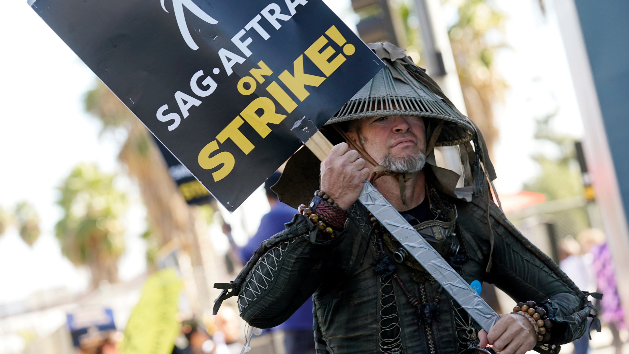 FILE - SAG-AFTRA member Bruce D. Mitchell participates in a post apocalyptic-themed picket line outside Netflix studios, Nov. 8, 2023, in Los Angeles. Hollywood’s actors have voted to ratify the deal with studios that ended their strike after nearly four months, leaders announced Tuesday, Dec. 5, 2023. (AP Photo/Chris Pizzello, File)