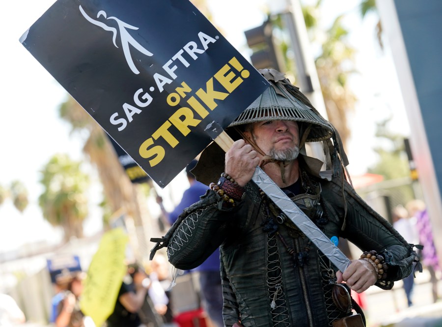 FILE - SAG-AFTRA member Bruce D. Mitchell participates in a post apocalyptic-themed picket line outside Netflix studios, Nov. 8, 2023, in Los Angeles. Hollywood’s actors have voted to ratify the deal with studios that ended their strike after nearly four months, leaders announced Tuesday, Dec. 5, 2023. (AP Photo/Chris Pizzello, File)