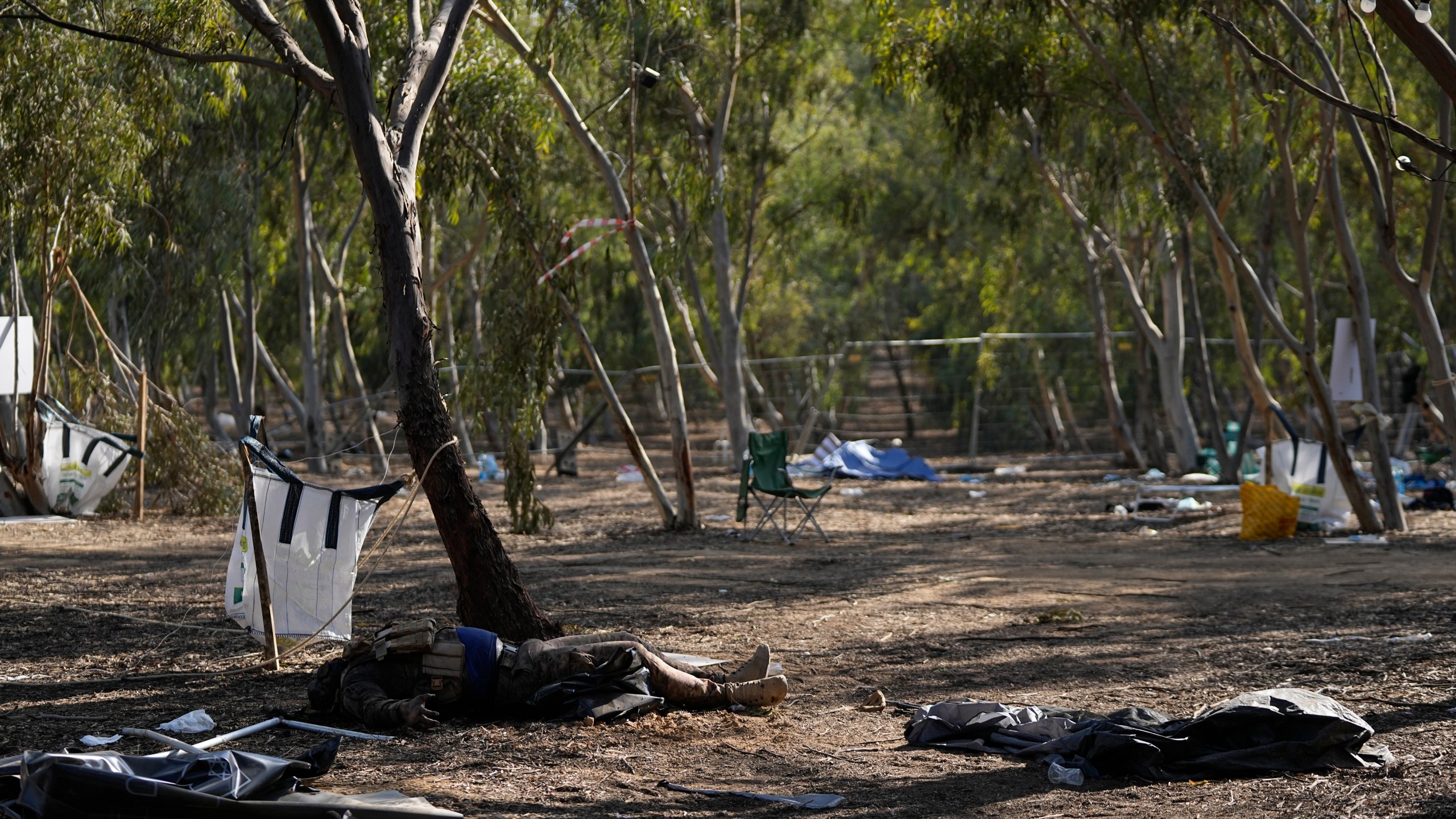 FILE - The body of a killed Hamas militant lies on the ground at the site of a music festival, near the border with the Gaza Strip in southern Israel, Thursday, Oct. 12, 2023. At least 260 Israeli festivalgoers were killed during the attack. Israeli officials say victim testimony and evidence gathered by rights groups indicate that Hamas militants carried out widespread sexual and gender-based crimes during their Oct. 7 attack in southern Israel. (AP Photo/Ohad Zwigenberg, File)