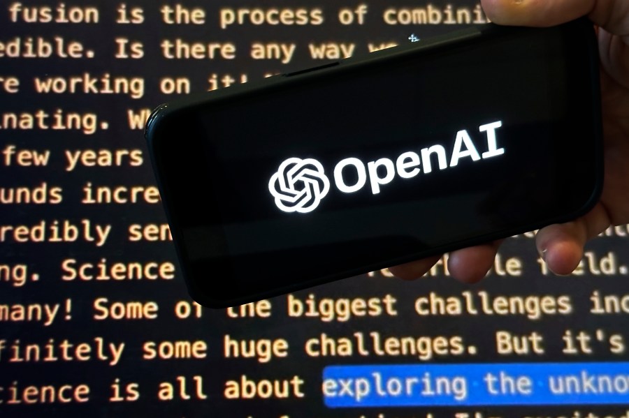 File - The OpenAI logo appears on a mobile phone in front of a screen showing part of the company website in this photo taken on Nov. 21, 2023 in New York. Negotiators will meet this week to hammer out details of European Union artificial intelligence rules but the process has been bogged down by a simmering last-minute battle over how to govern systems that underpin general purpose AI services like OpenAI's ChatGPT and Google's Bard chatbot. (AP Photo/Peter Morgan, File)