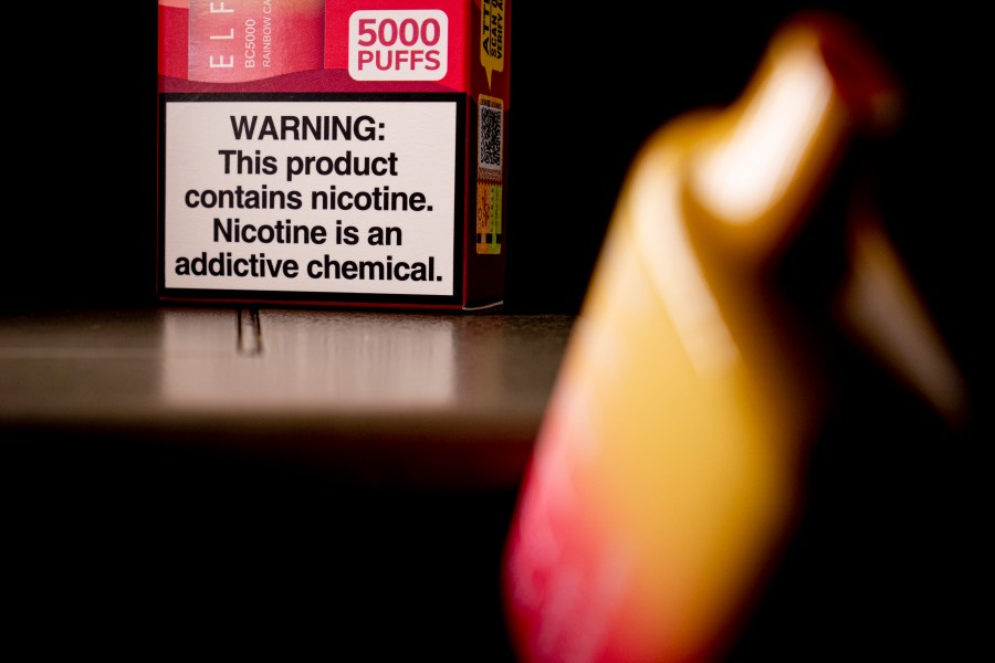 FILE - An Elf Bar disposable vaping pod device and a health warning on its packaging is displayed, Monday, June 26, 2023, in Washington. U.S. lawmakers are demanding information on federal efforts to stop the recent influx of kid-appealing electronic cigarettes from China. A letter sent Thursday, Dec. 7, 2023, by a congressional committee investigating Chinese policies called attention to “the extreme proliferation of illicit vaping products.” (AP Photo/Andrew Harnik, File)