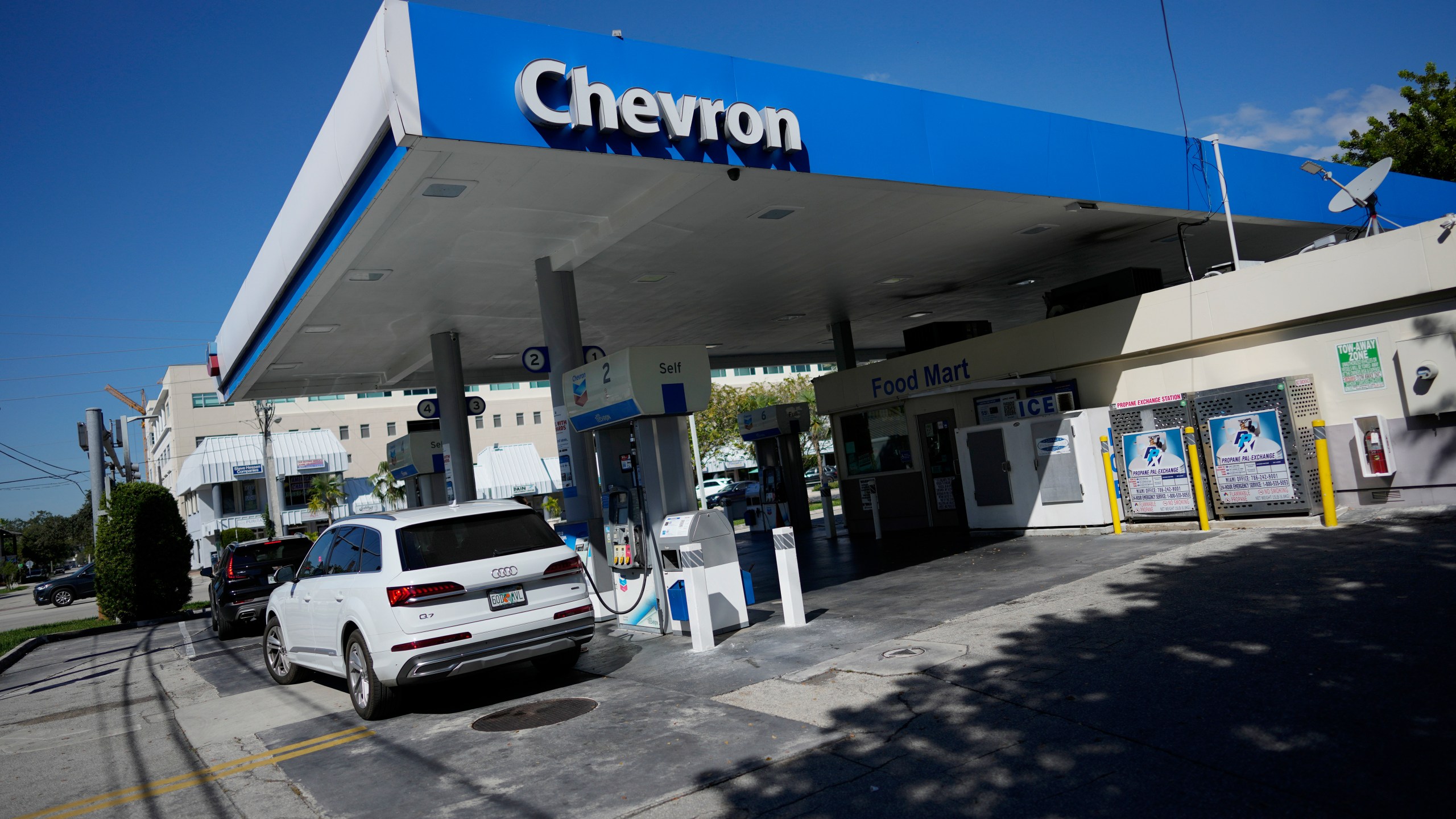 File - Drivers refuel at a Chevron gas station, Monday, Oct. 23, 2023, in South Miami, Fla. A big explanation for the recent decline in gas prices is seasonality — with prices at the pump almost always easing at this time of year. (AP Photo/Rebecca Blackwell, File)