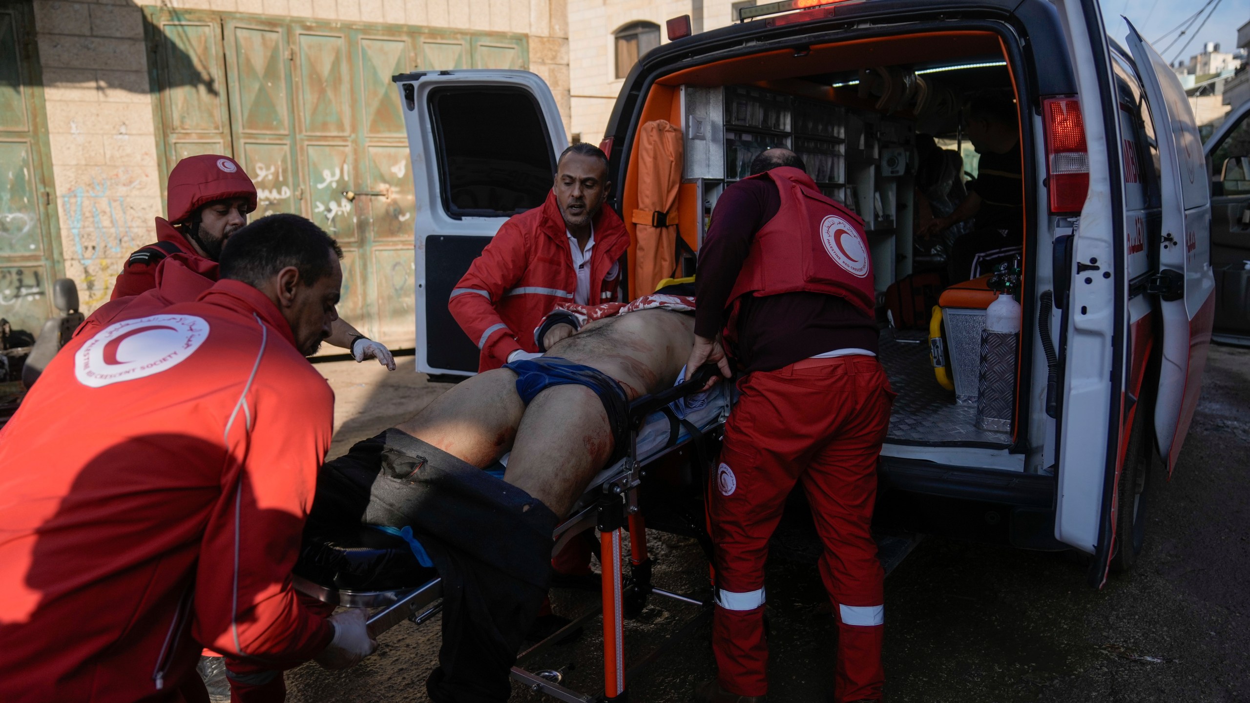 Medics evacuate a wounded Palestinian following an Israeli military raid in Faraa refugee camp, West Bank, Friday, Dec. 8, 2023. The Palestinian Health Ministry says that five Palestinians were killed when Israeli forces raided the camp prompting fighting with local militants. (AP Photo/Majdi Mohammed)