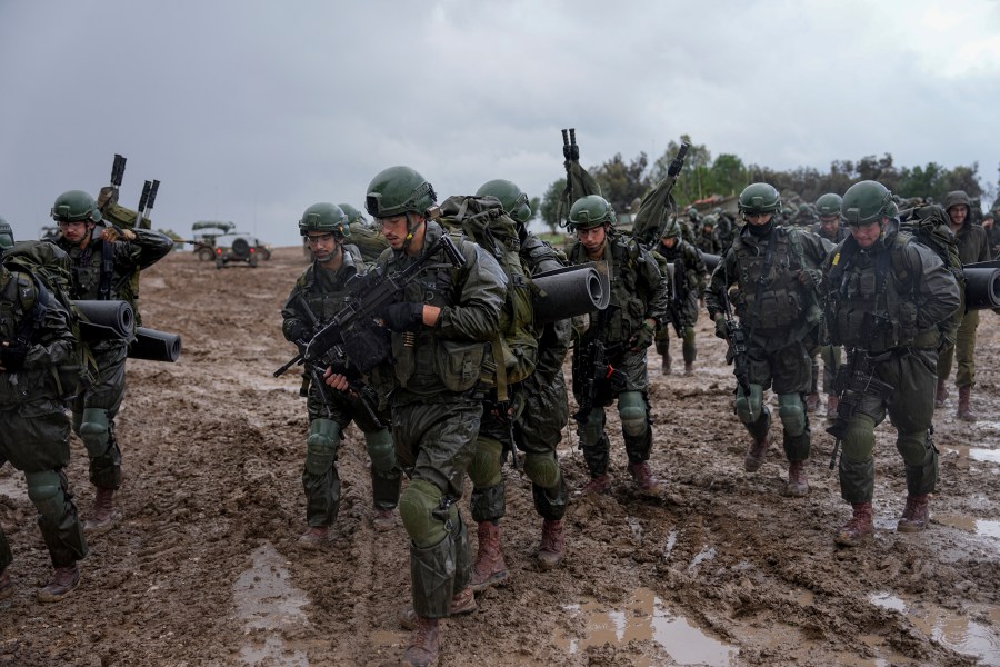 Israeli soldiers prepare to enter the Gaza Strip, at a staging area near the Israeli-Gaza border, in southern Israel, Wednesday, Dec. 13, 2023. The army is battling Palestinian militants across Gaza in the war ignited by Hamas' Oct. 7 attack into Israel. (AP Photo/Ohad Zwigenberg)