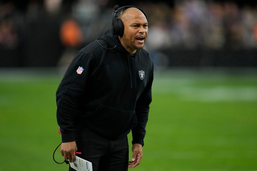 Las Vegas Raiders interim head coach Antonio Pierce makes a call during the first half of an NFL football game against the Minnesota Vikings, Sunday, Dec. 10, 2023, in Las Vegas. (AP Photo/John Locher)