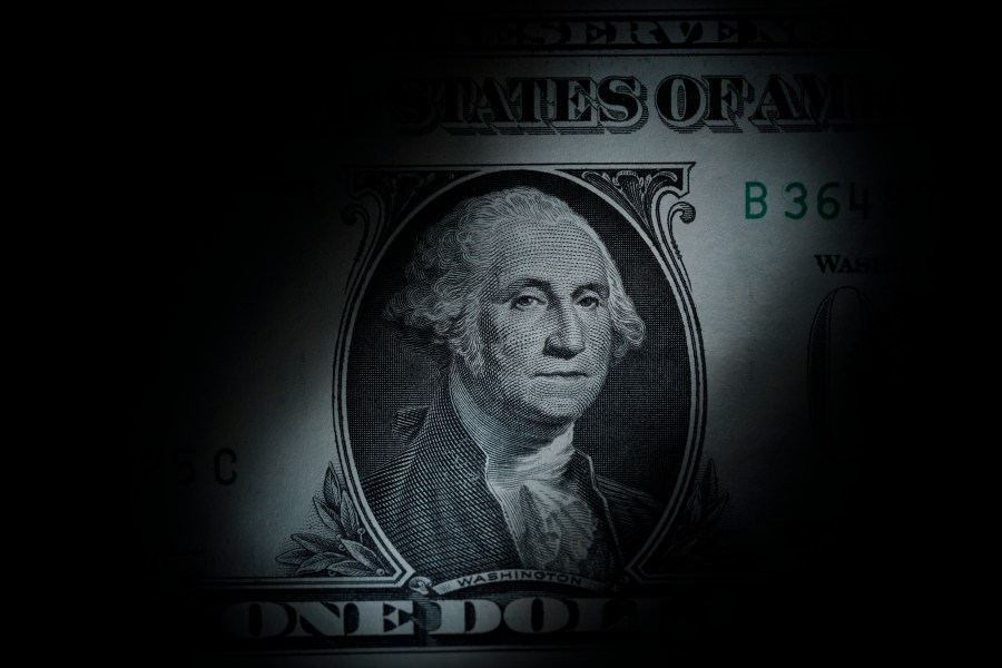 FILE - The likeness of George Washington is seen on a U.S. one dollar bill, March 13, 2023, in Marple Township, Pa. The Congressional Budget Office said Friday, Dec. 15, that it expects inflation to nearly hit the Federal Reserve's 2% target rate in 2024, as overall growth is expected to slow and unemployment is expected to rise into 2025, according to updated economic projections for the next two years. (AP Photo/Matt Slocum, File)