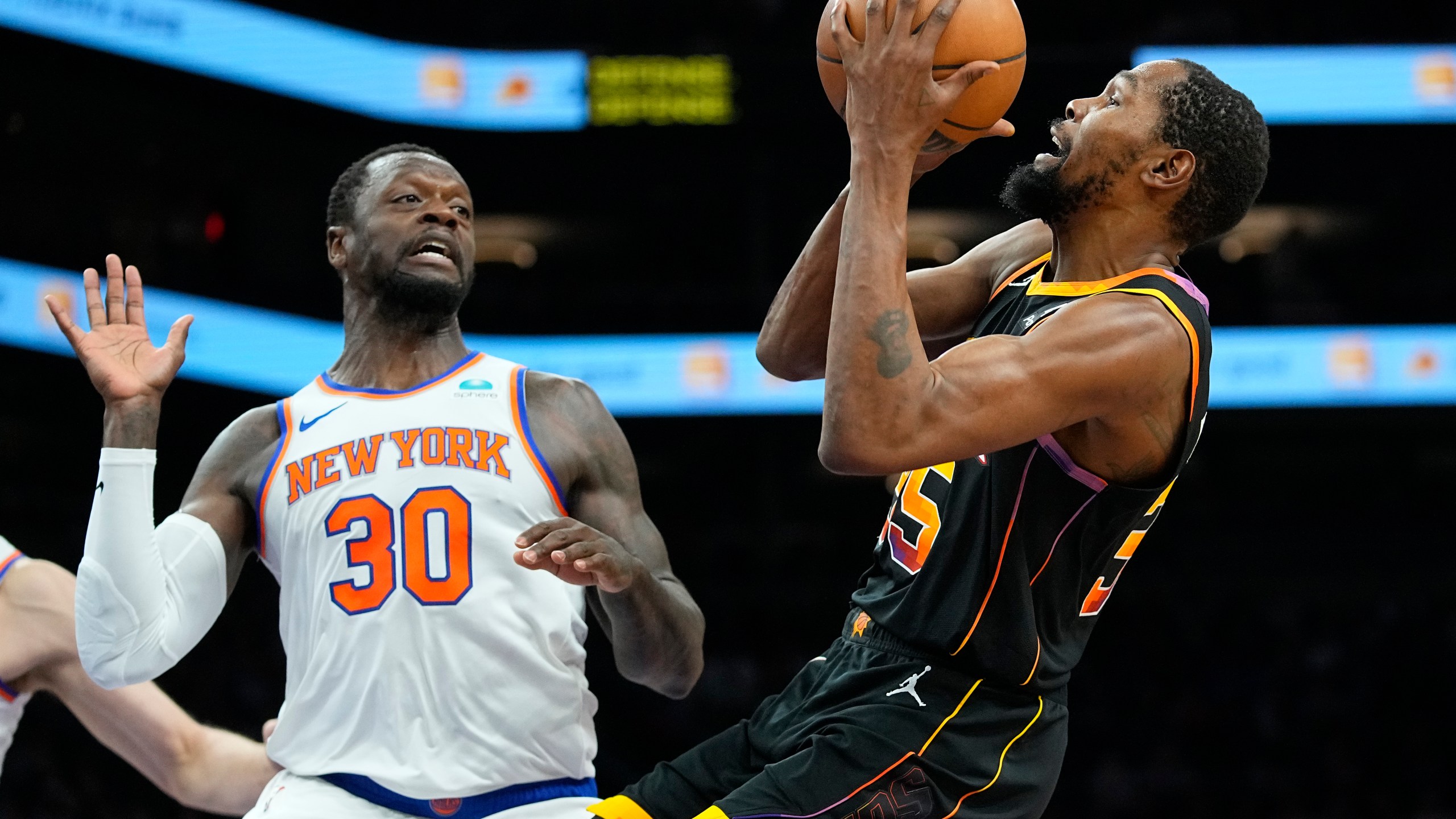 Phoenix Suns forward Kevin Durant drives as New York Knicks forward Julius Randle (30) defends during the first half of an NBA basketball game, Friday, Dec. 15, 2023, in Phoenix. (AP Photo/Matt York)