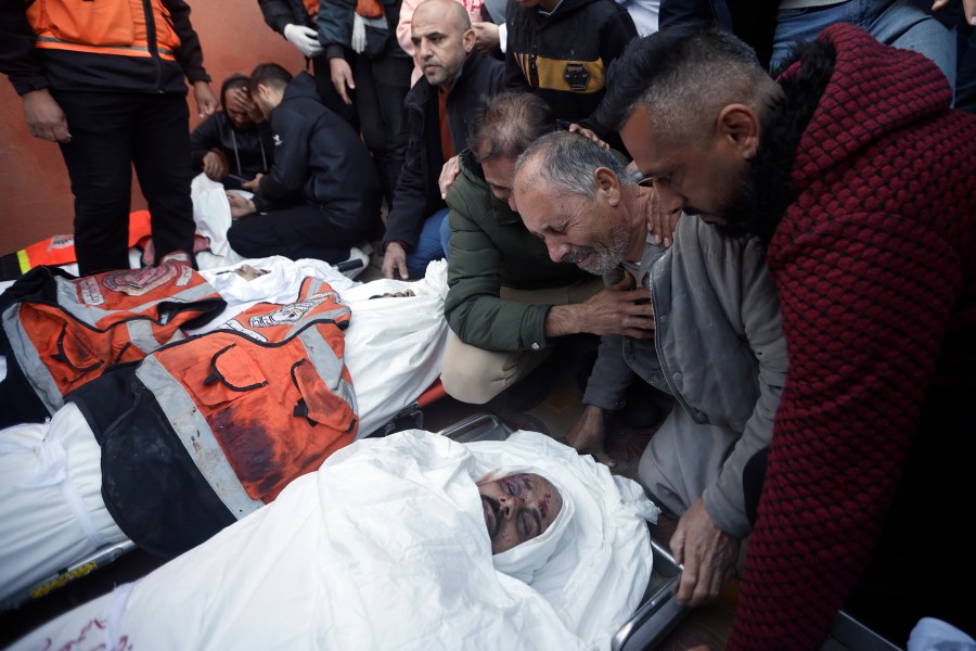 Palestinians mourn over the bodies of Al Jazeera cameraman, Samer Abu Daqqa, and three civil defence officers who were killed in Israeli airstrikes, during their funerals in the town of Khan Younis, southern Gaza Strip. Saturday, Dec. 16, 2023. (AP Photo/Mohammed Dahman)