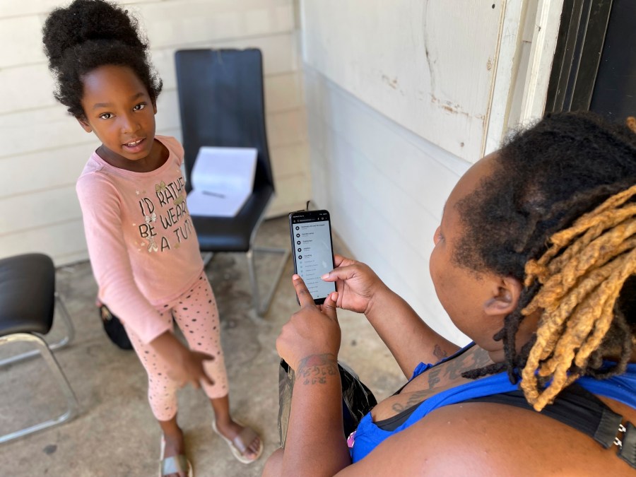 Tameka and her 8-year-old-daughter hang out outside of their apartment in Atlanta Oct. 2, 2023. Tameka's daughter is the only one of her four children who regularly leaves the apartment to play with other children or attend a local after-school program. She’s never attended school, and is one of tens of thousands of children nationwide who are not enrolled in any kind of schooling. (AP Photo/Bianca Vázquez Toness)